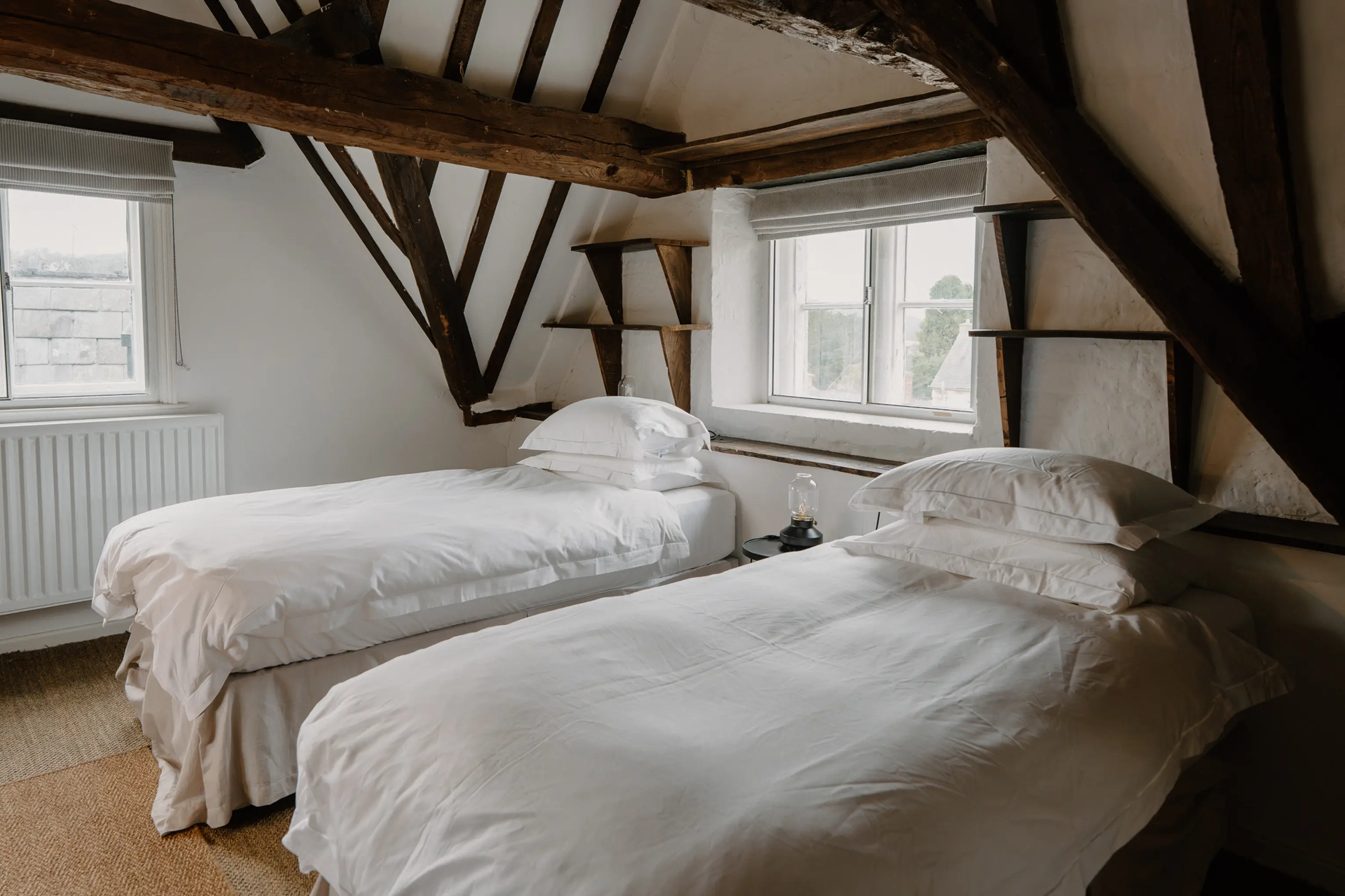 Twin attic bedroom at ARC Painswick with two single beds and exposed beams