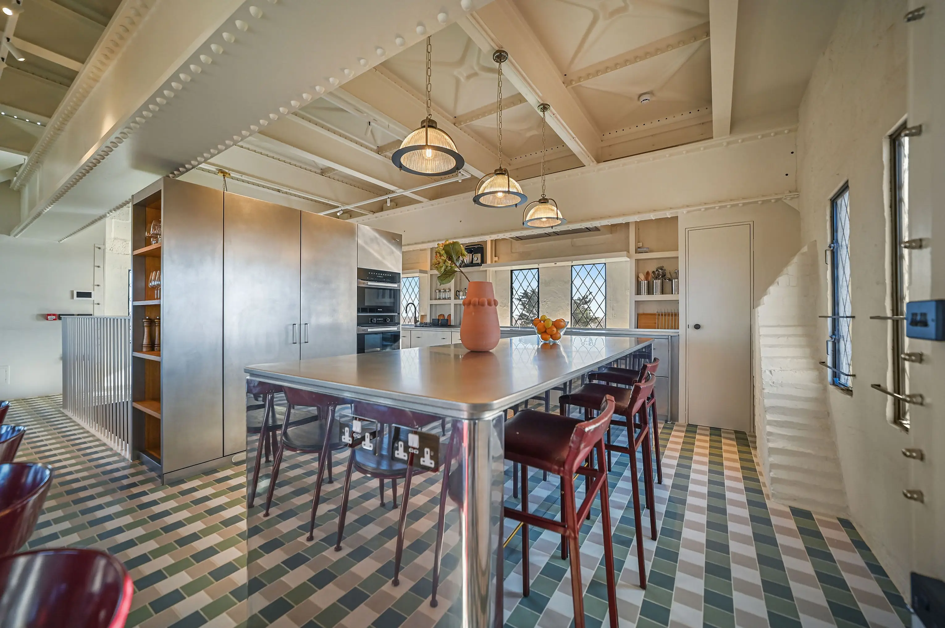 Bar and dining area at ARC Thorpeness with high stools at a long counter and a patterned tiled floor