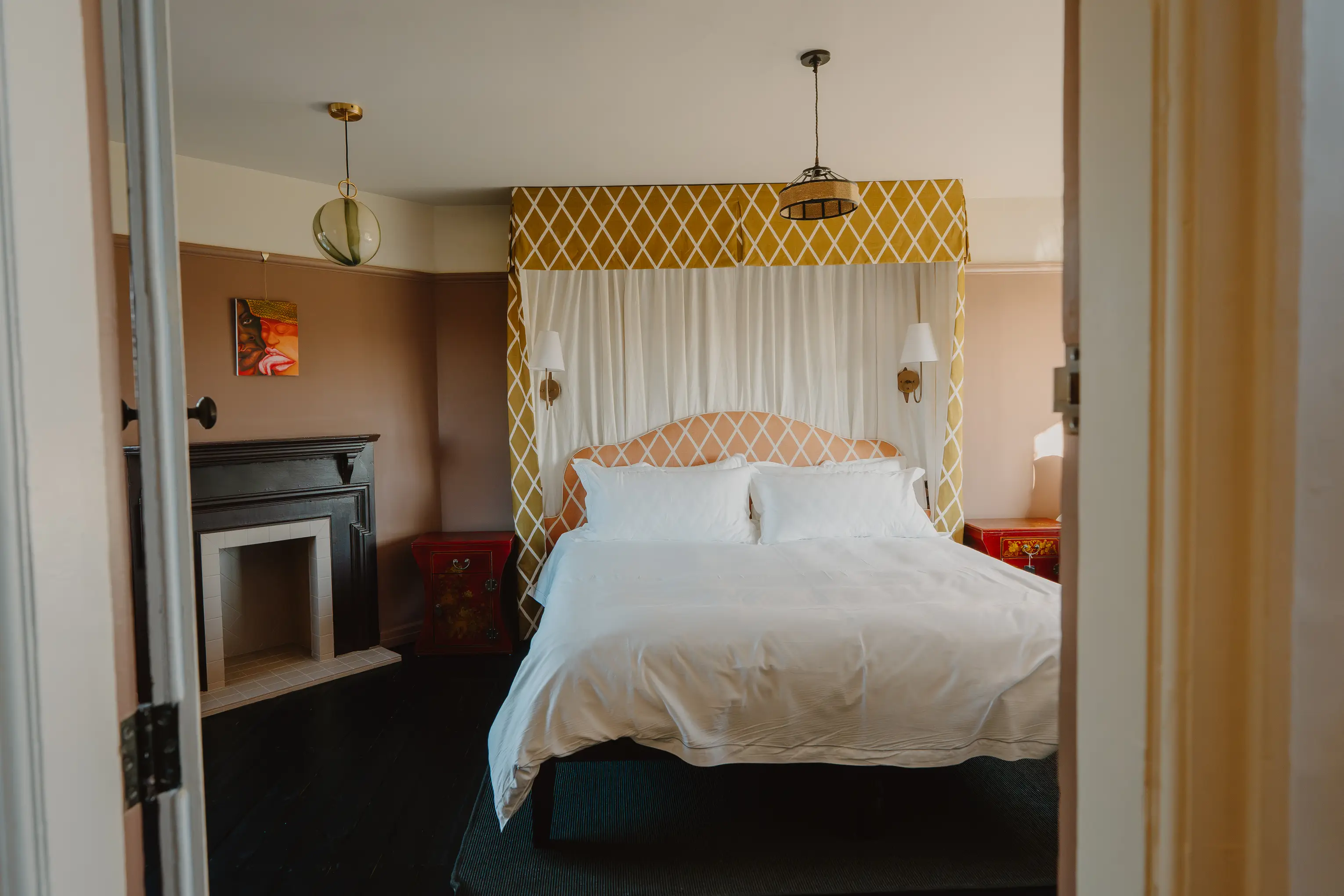 Bedroom at ARC Thorpeness with a yellow scalloped canopy headboard against dark walls