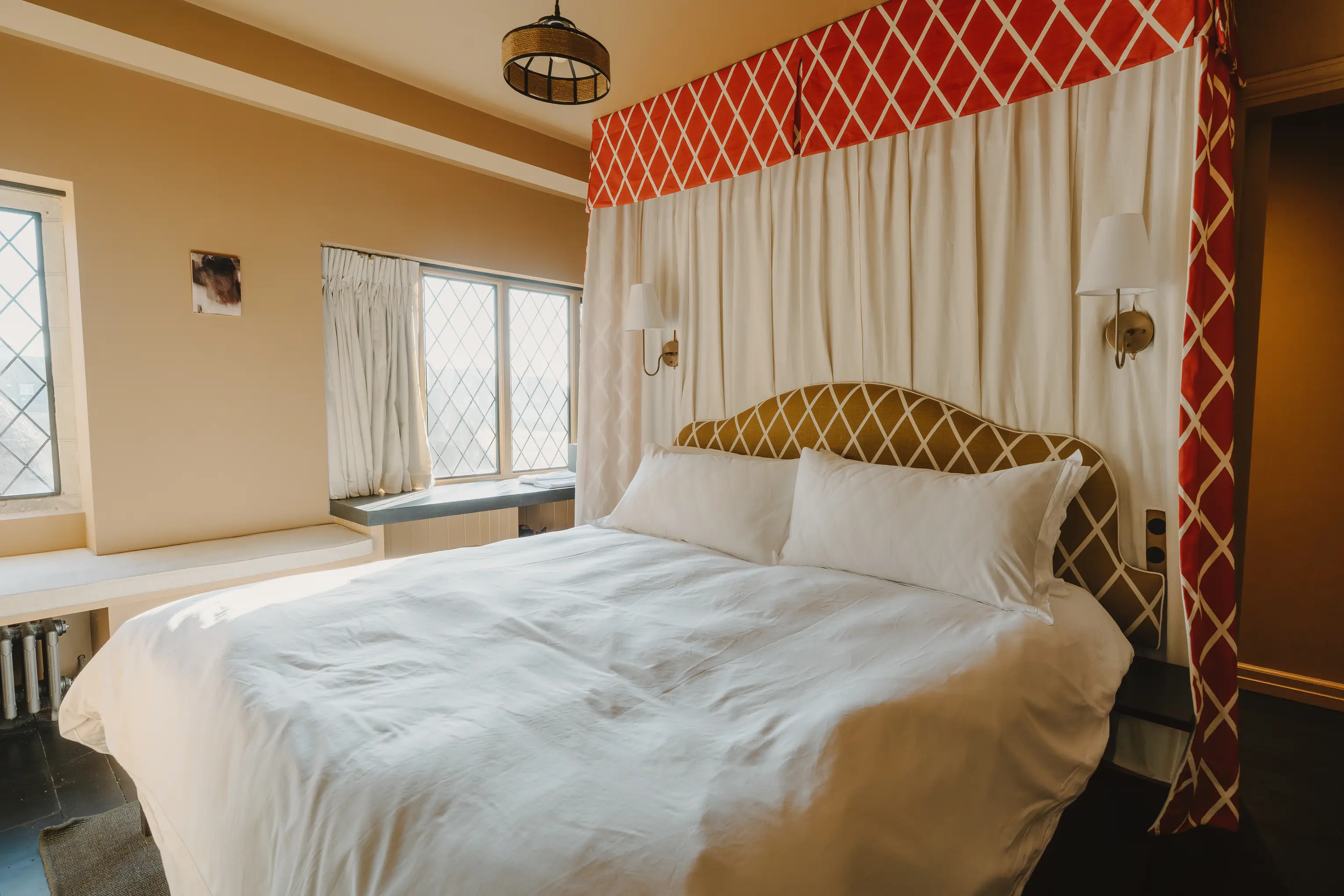 Bedroom at ARC Thorpeness with a red patterned canopy headboard and a double bed