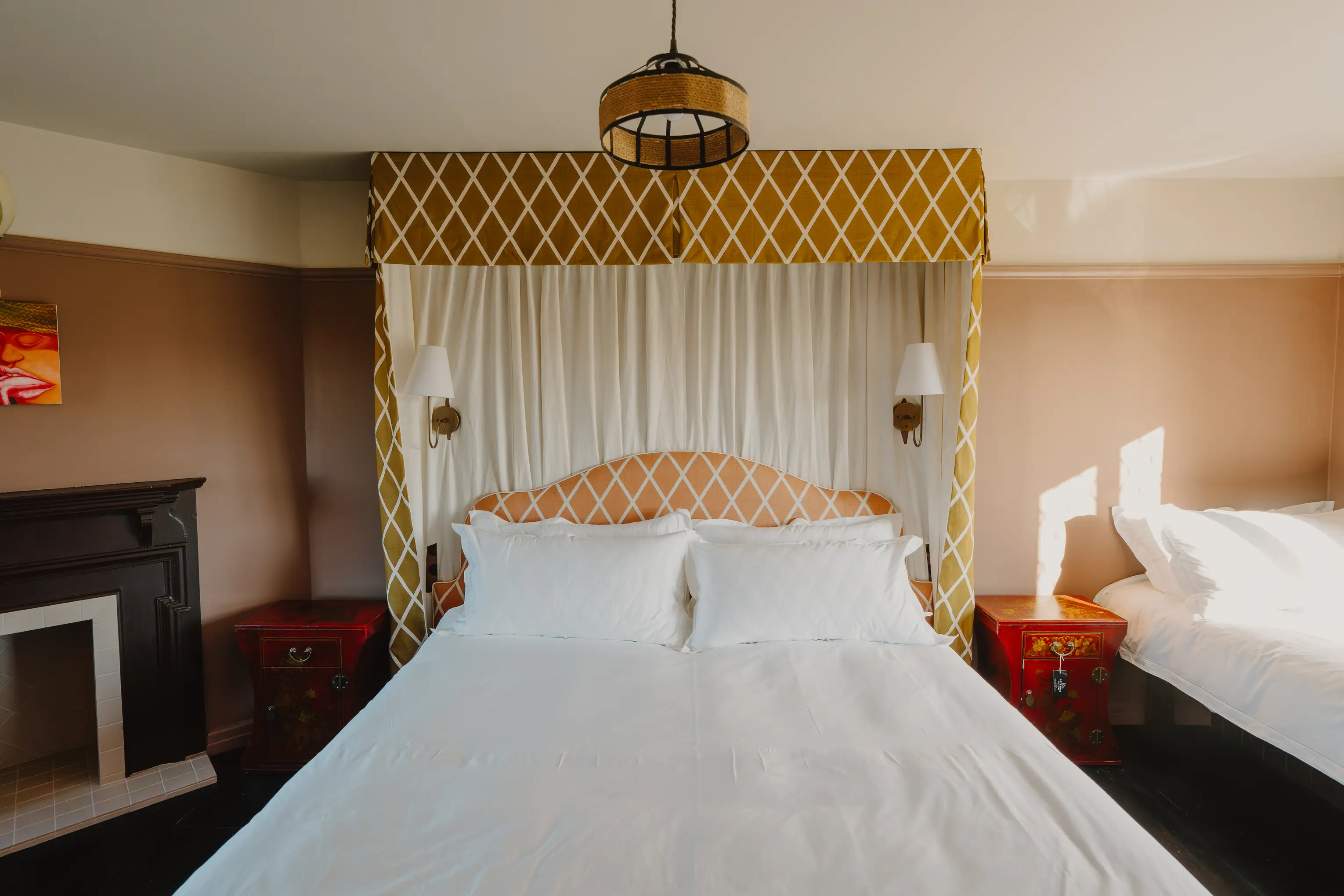 Bedroom at ARC Thorpeness with a yellow patterned canopy headboard and a pendant light