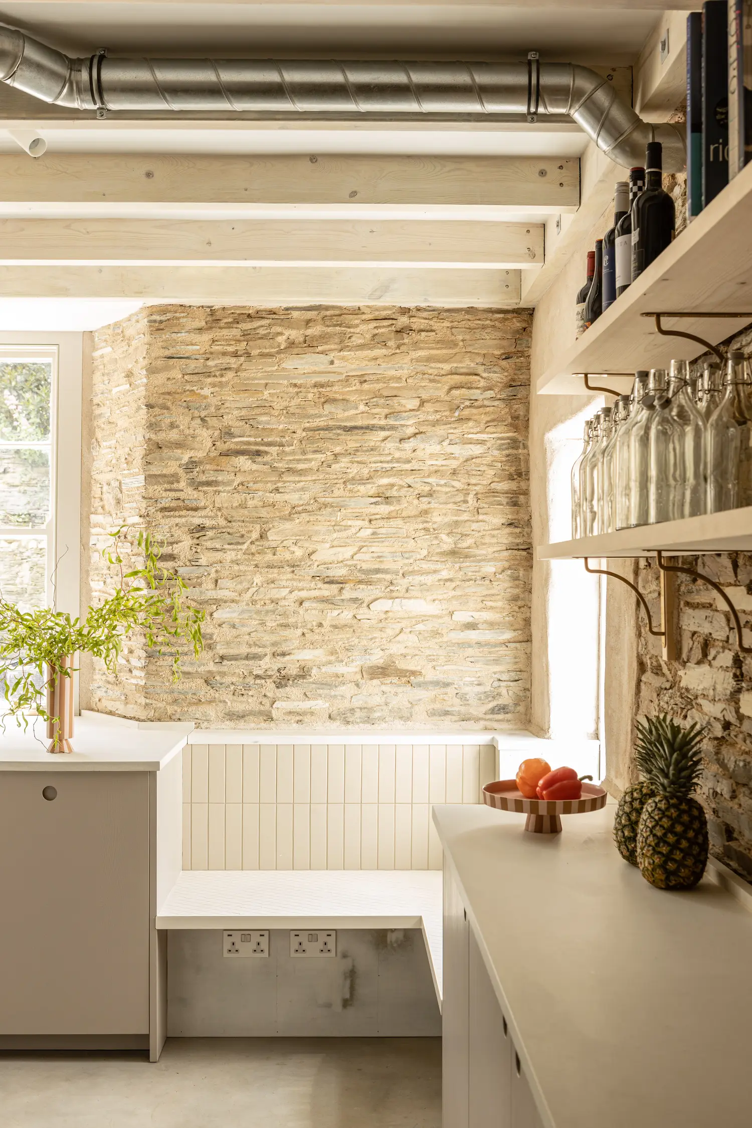 A modern kitchen designed for large group stays, architecturally designed and restored with exposed brick walls, wooden beams.