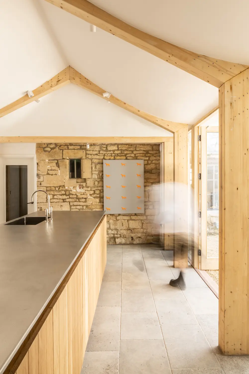 Modern kitchen with wooden beams, stone walls, and a sleek countertop available for large group cooking and dining for guests staying at ARC Painswick.
