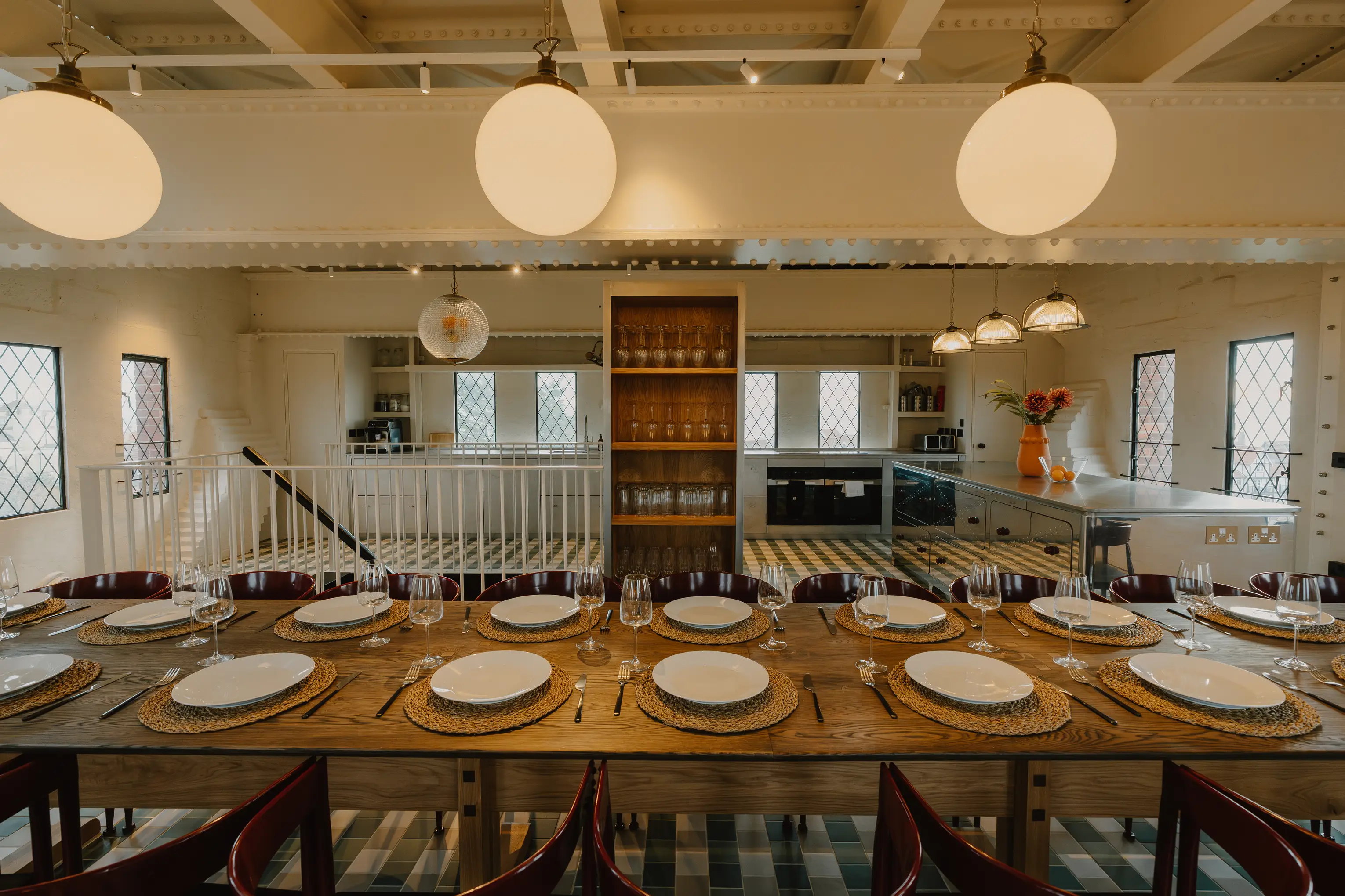 Dining and kitchen space at ARC Thorpeness with a table laid for guests beside tall windows