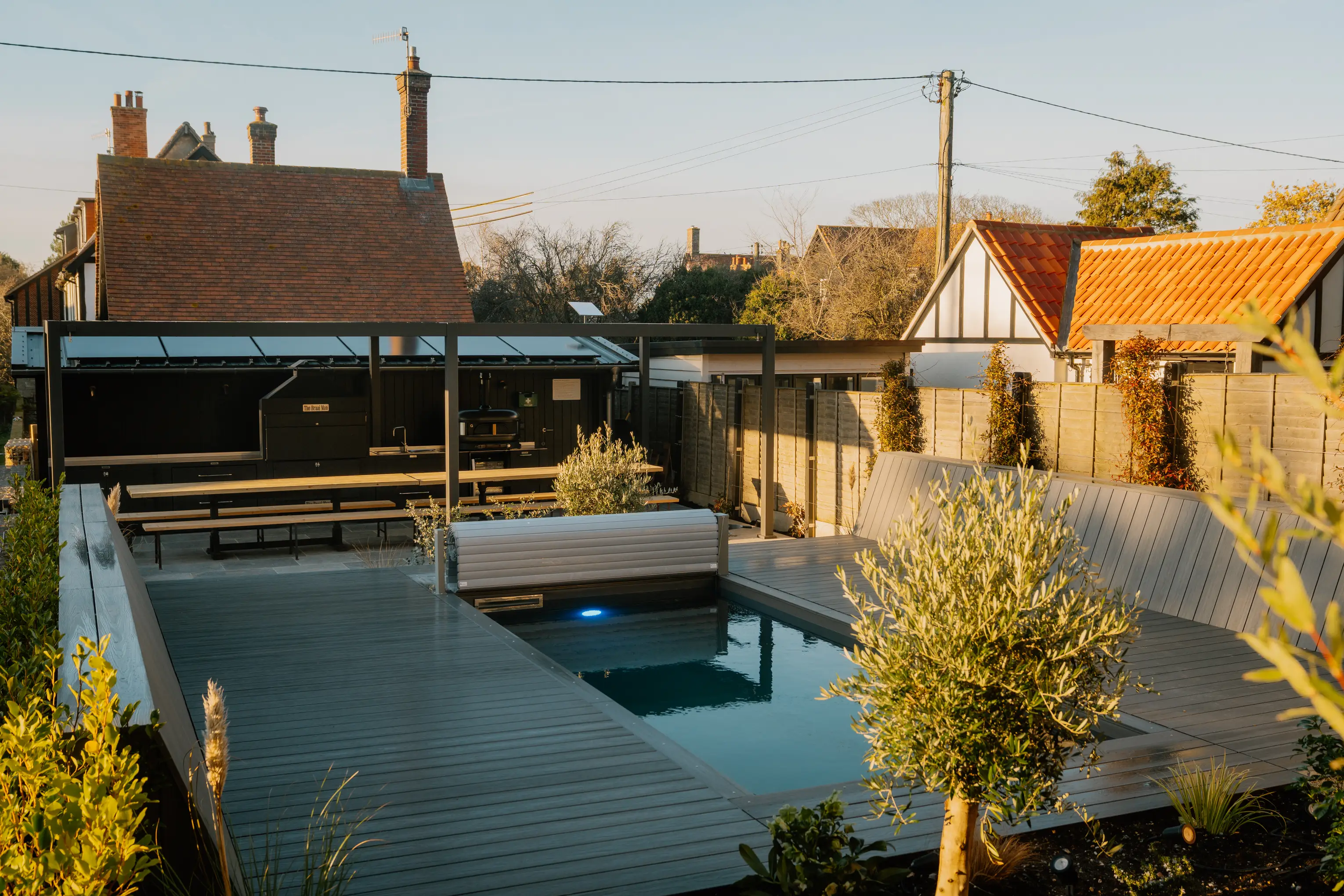 Mediterranean garden at ARC Thorpeness with an outdoor pool and decking at dusk