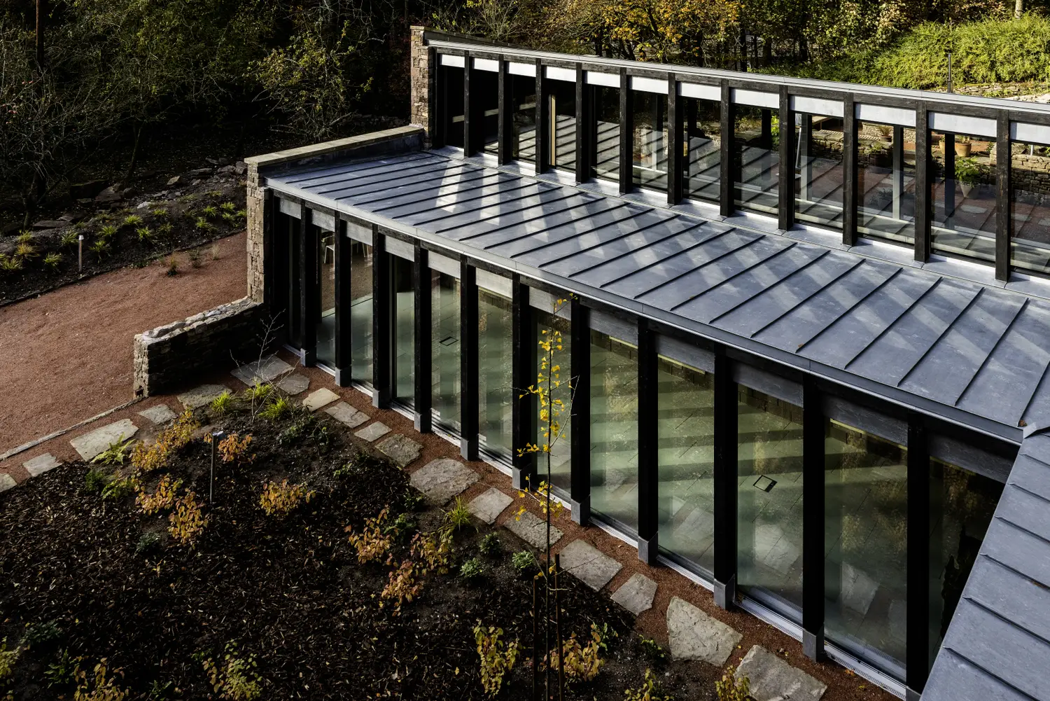 A shot of ARC Peaks outdoor space, with large glass windows looking in to the yoga studio available for group stays in the Peak District.