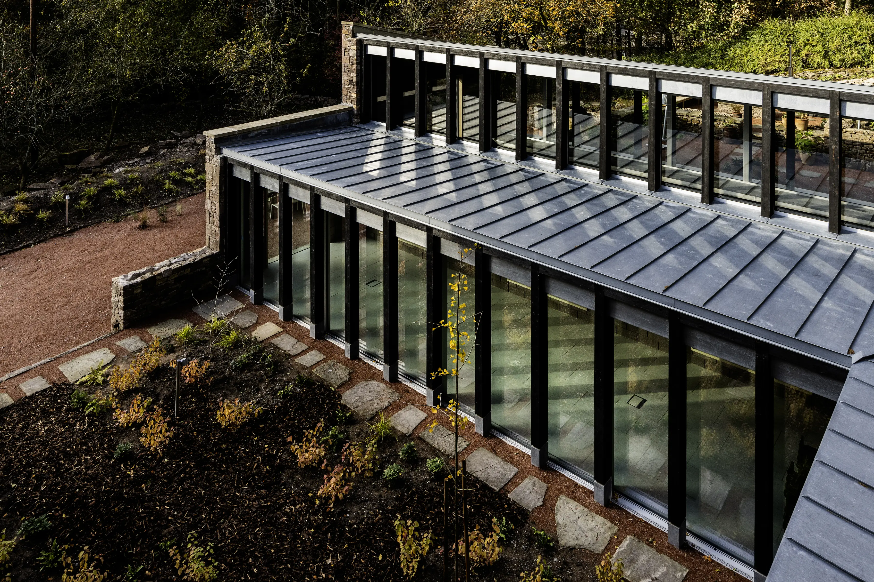 A shot of ARC Peaks outdoor space, with large glass windows looking in to the yoga studio available for group stays in the Peak District.