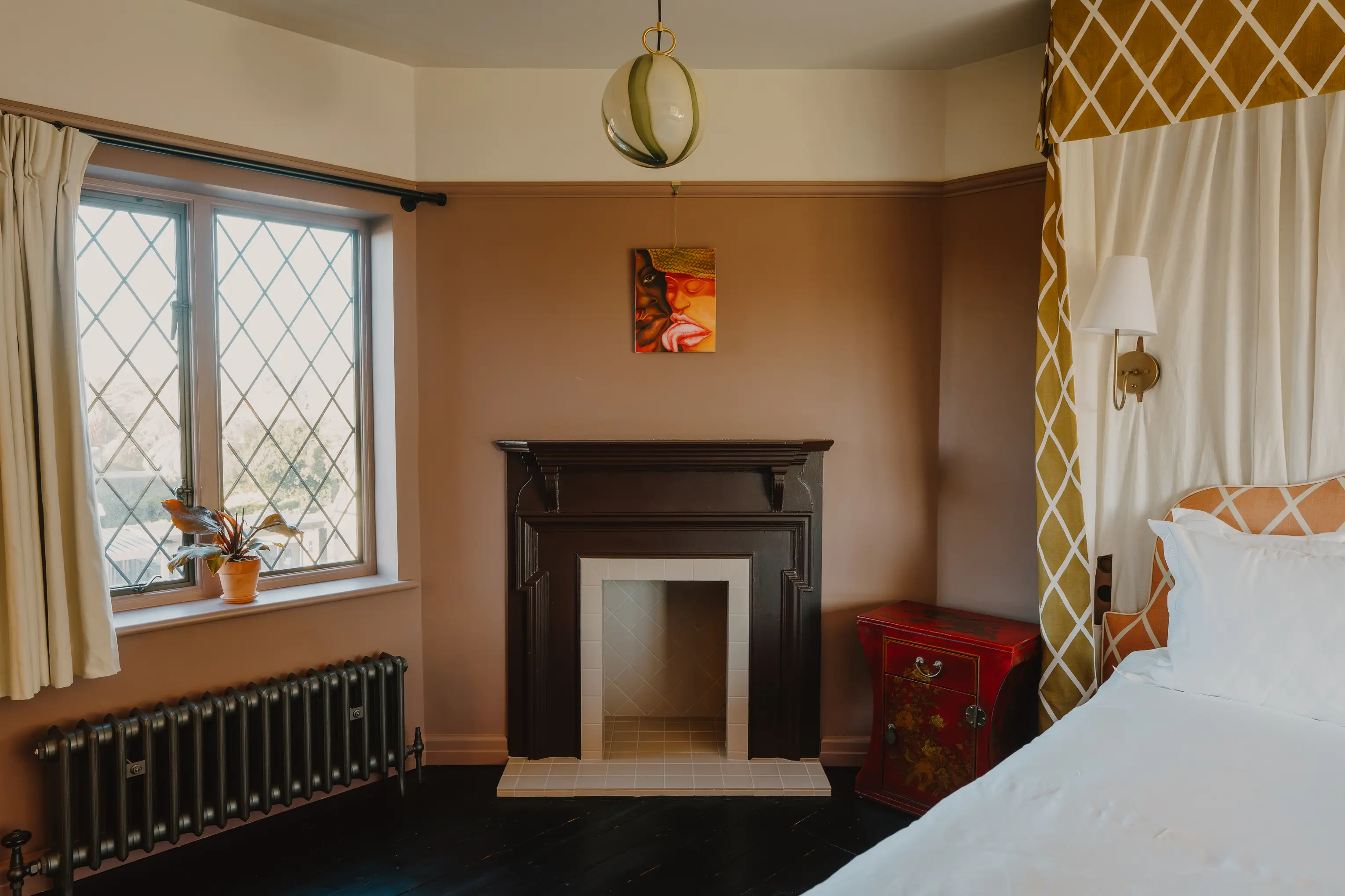 Bedroom at ARC Thorpeness with a marble fireplace and a coastal view through the window