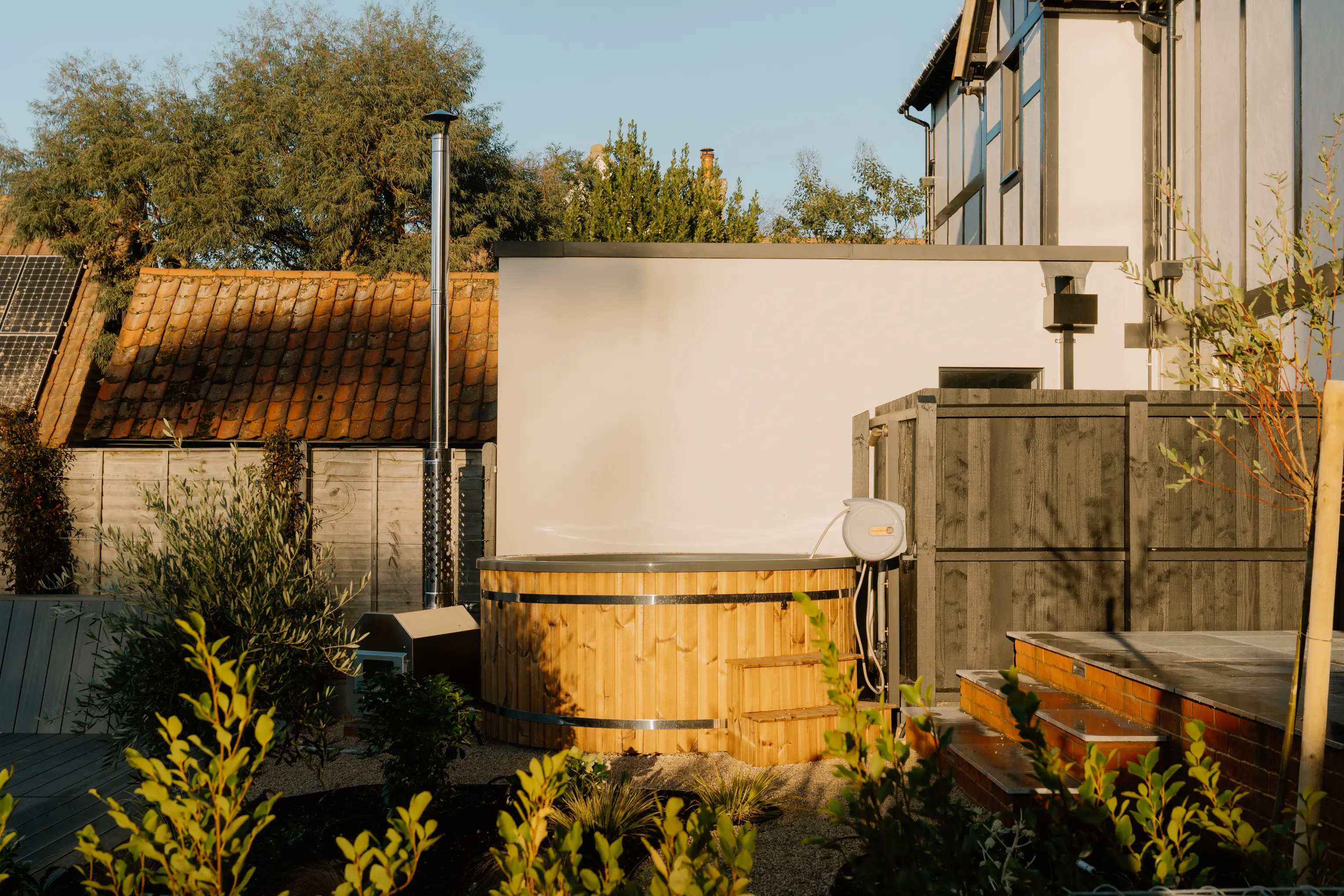 Garden courtyard at ARC Thorpeness with seating and rendered walls in the evening light