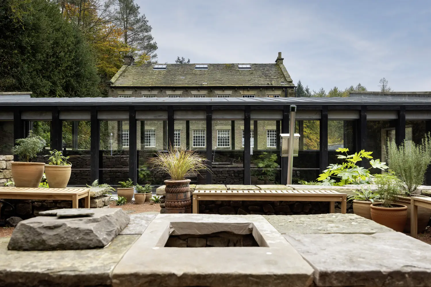 A photo looking in at the outdoor fire pit and dining area available for group stays at ARC Peak District.