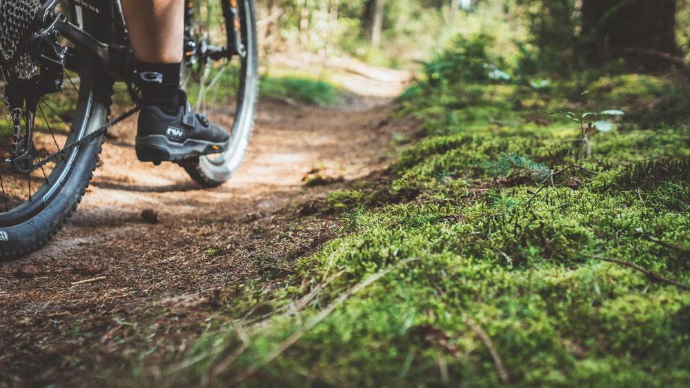 Detailbild Schuhe beim Radfahren über einen Trail