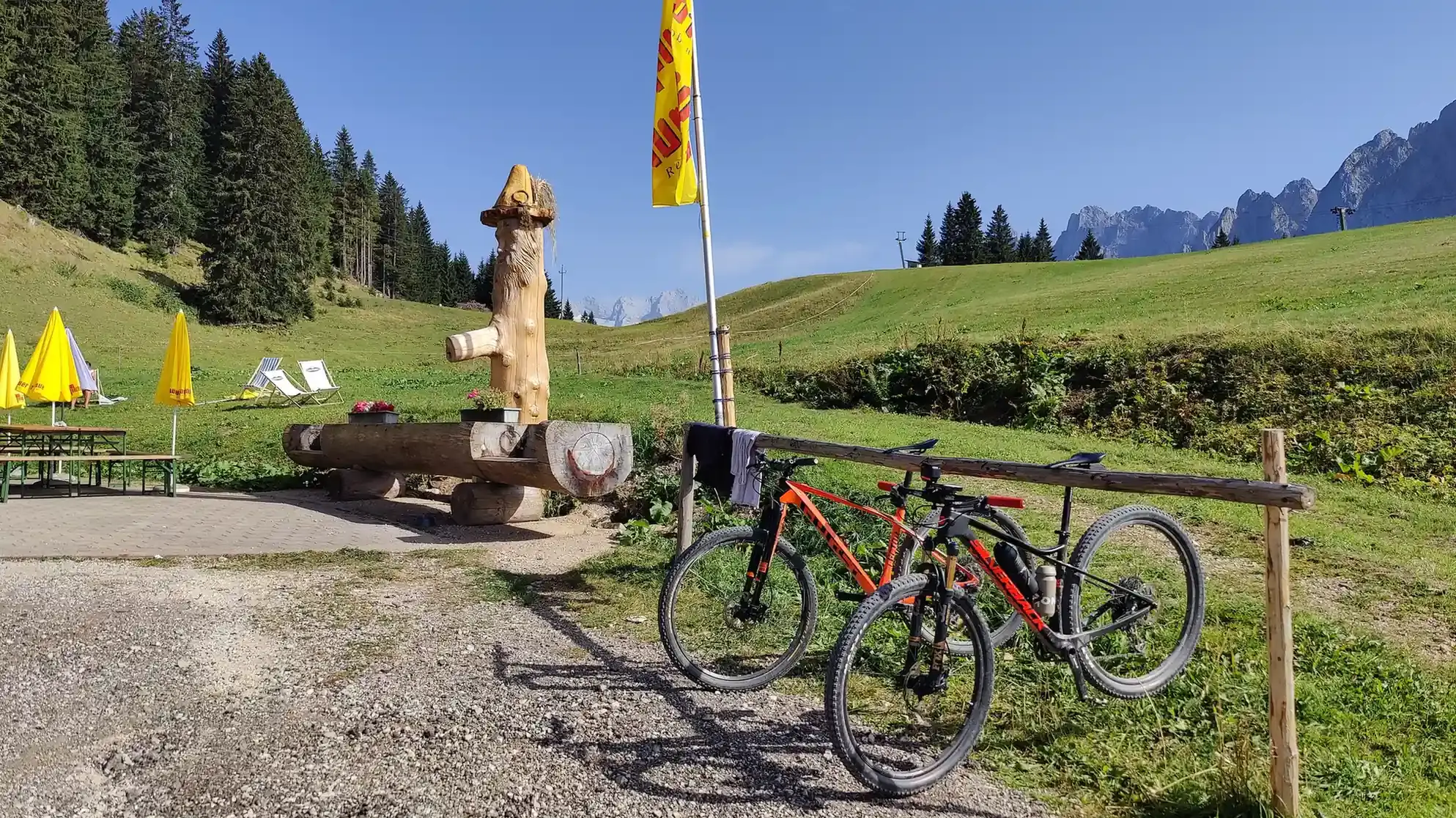 Pause beim Radfahren in der Sonne auf einer Alm mit Brunnen.