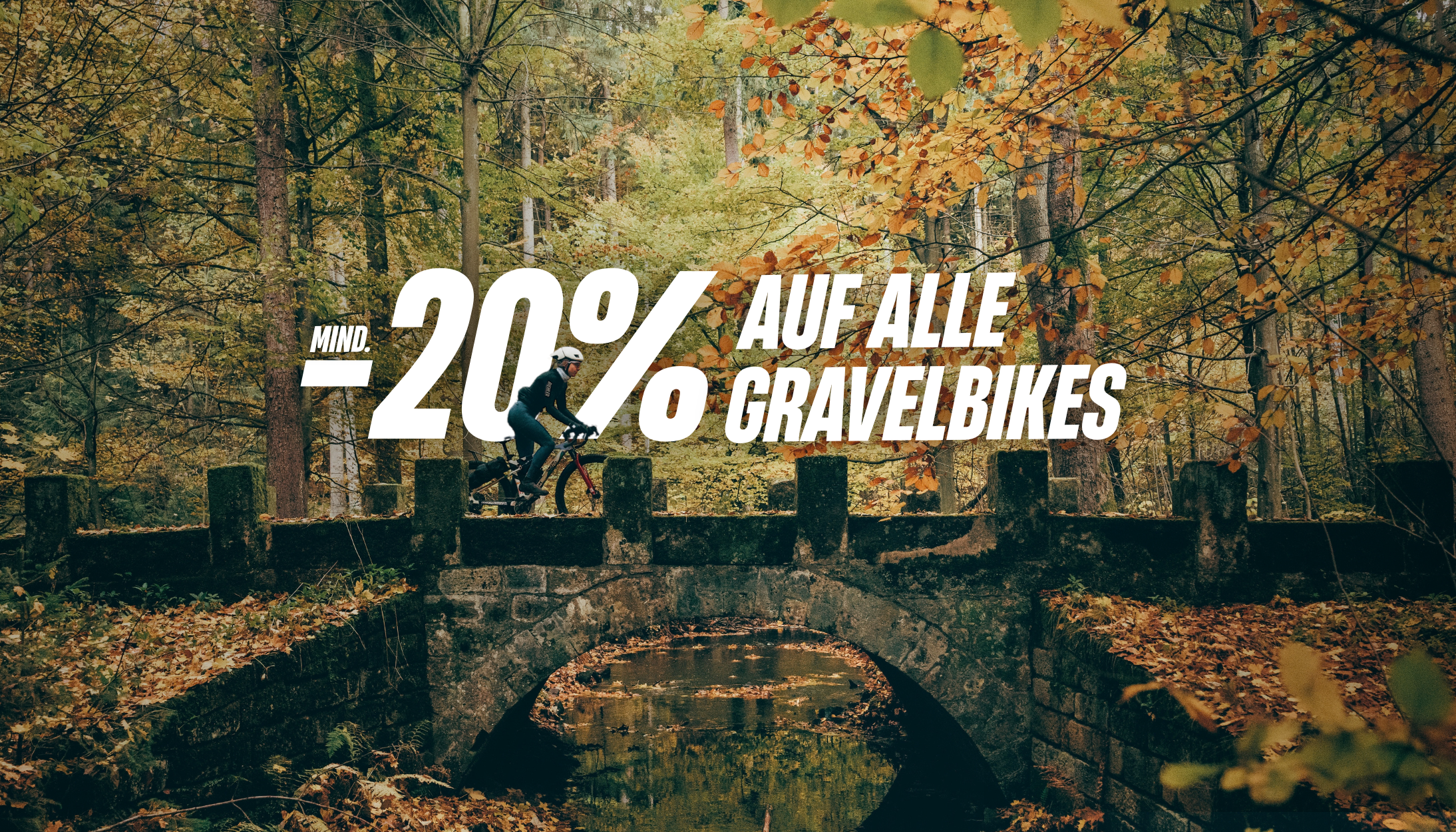 Gravelbike-Fahrerin mit Helm auf einer Brücke im Wald, darüber der Rabatttext „Mind. −20 % auf alle Gravelbikes“.