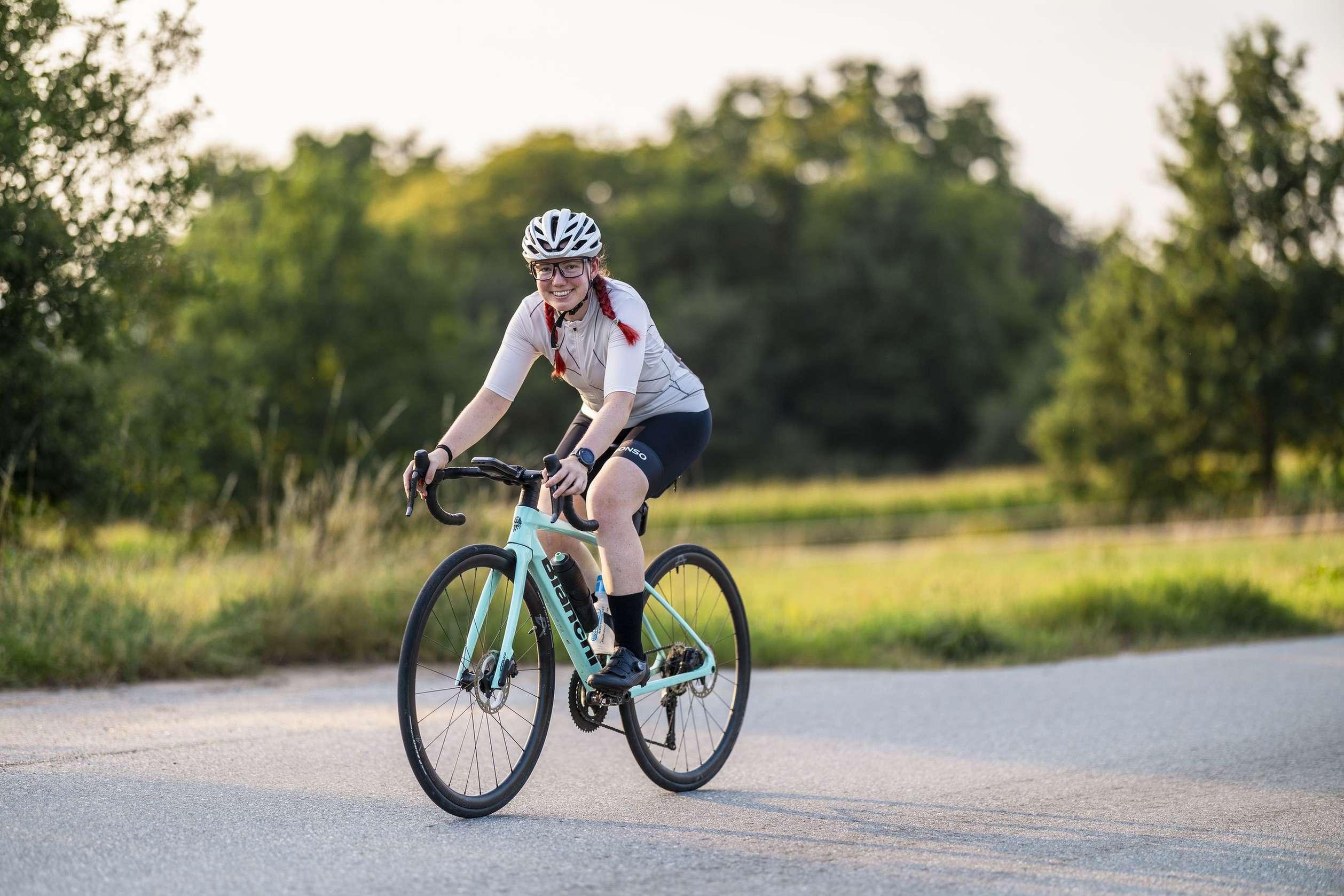 Frau beim Rennradfahren vor einer Naturkulisse