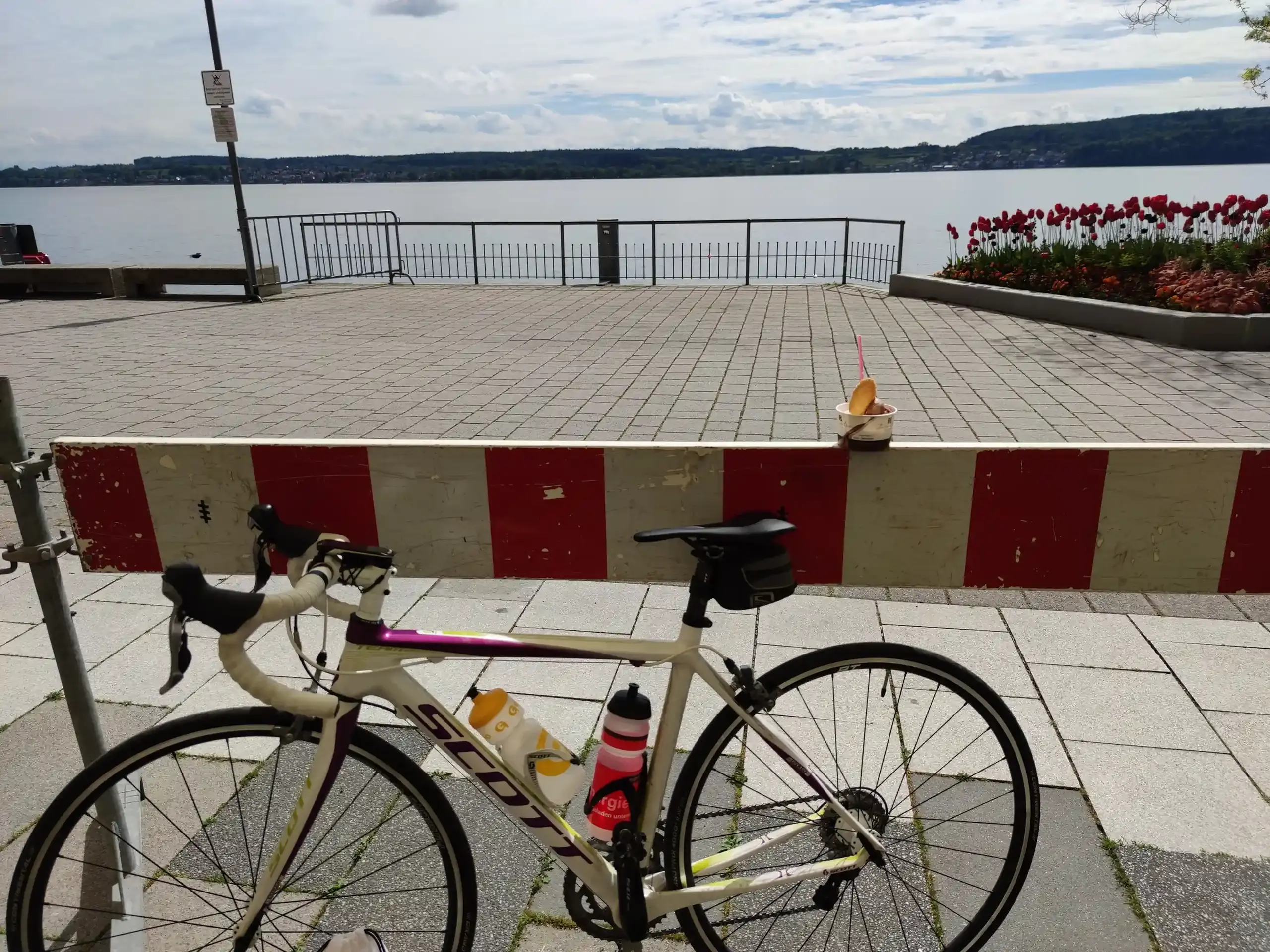 Ein Rennrad und ein Eis im Vordergrund - im Hintergrund der Bodensee.