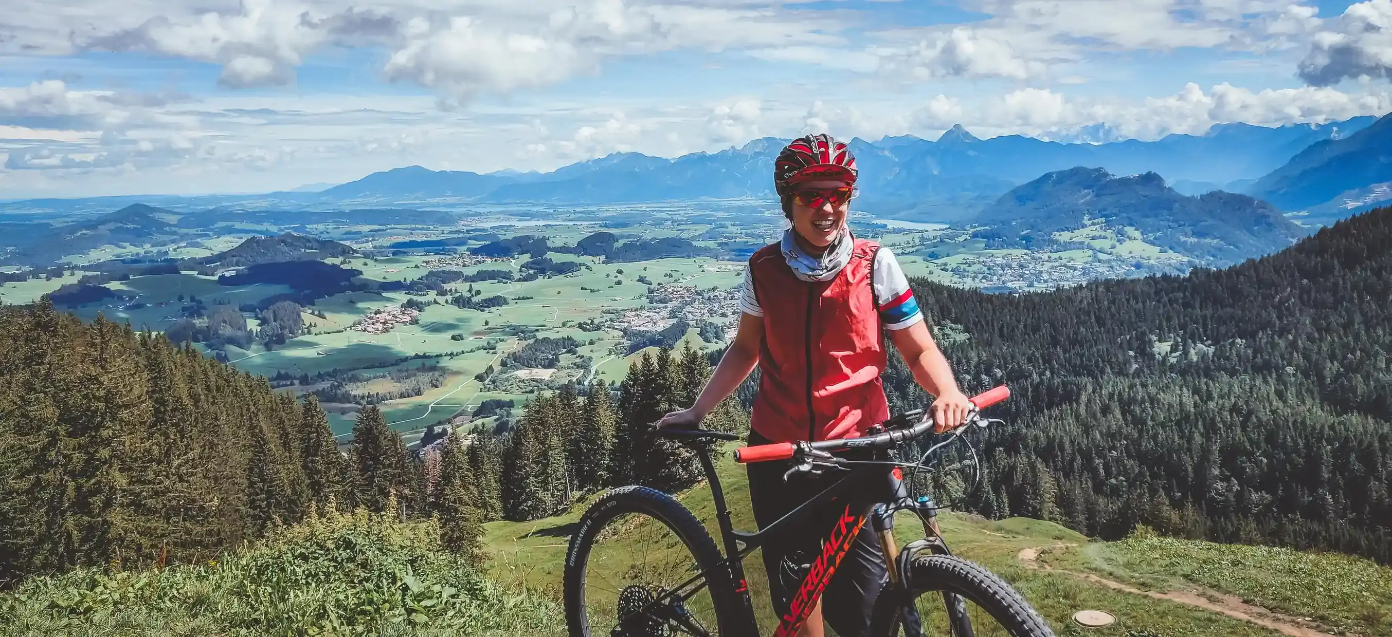 Glückliche Radfahrerin mit einem Biobike in den Bergen.