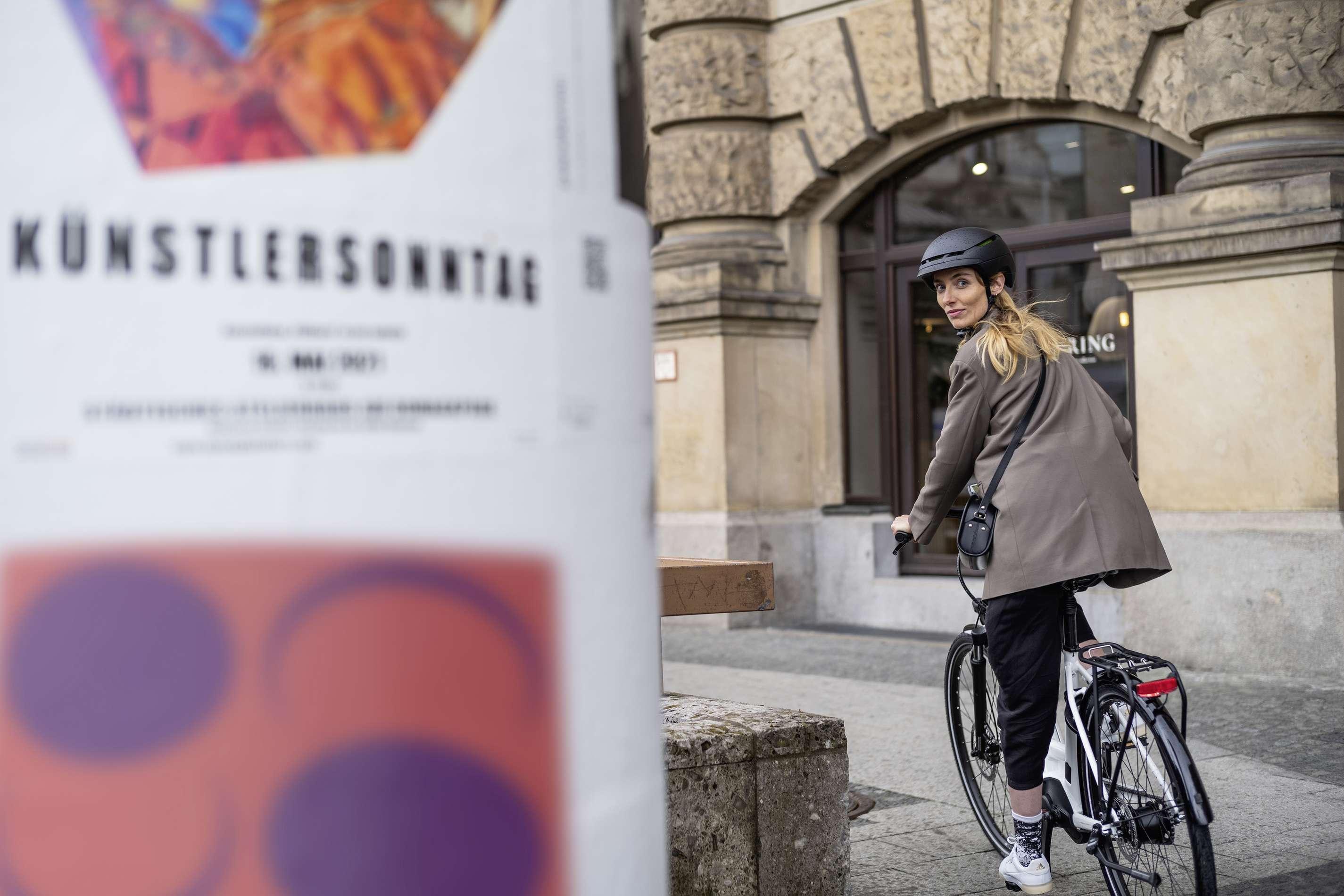 Radfahrerin radelt im Frühling durch die Stadt.