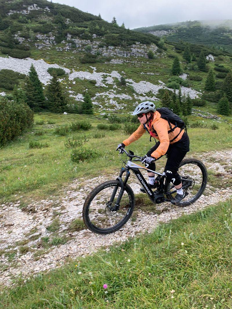 Lisa fährt mit dem E-Mtb in den Bergen auf einer Schotterpassage.