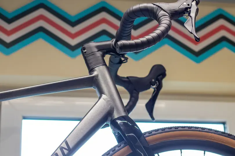 Seitliche Detailansicht eines Gravelbikes - man sieht ganz gut wie viel Platz der Reifen in der Gabel hat.