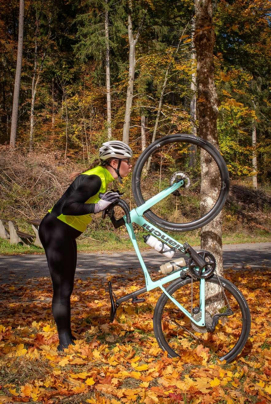Radfahrerin mit ihrem Rennrad im Herbstwald