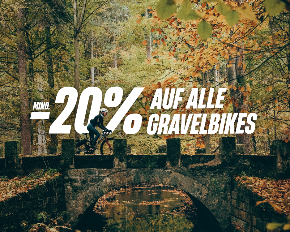Gravelbike-Fahrerin mit Helm auf einer Brücke im Wald, darüber der Rabatttext „Mind. −20 % auf alle Gravelbikes“.