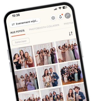 Een close-up, schuine weergave van een smartphone met de interface van de KRUU mobiele app. Het scherm toont een digitale fotogalerij getiteld "Alle Bilder" (Alle Beelden) gevuld met verschillende groepsfoto's genomen op een bruiloft. Op de foto's poseren gasten in formele kleding met leuke attributen zoals hartvormige glazen en "Just Married" bordjes. Het ontwerp van de app is strak en modern, met bovenaan navigatiepictogrammen voor instellingen, meldingen en delen.