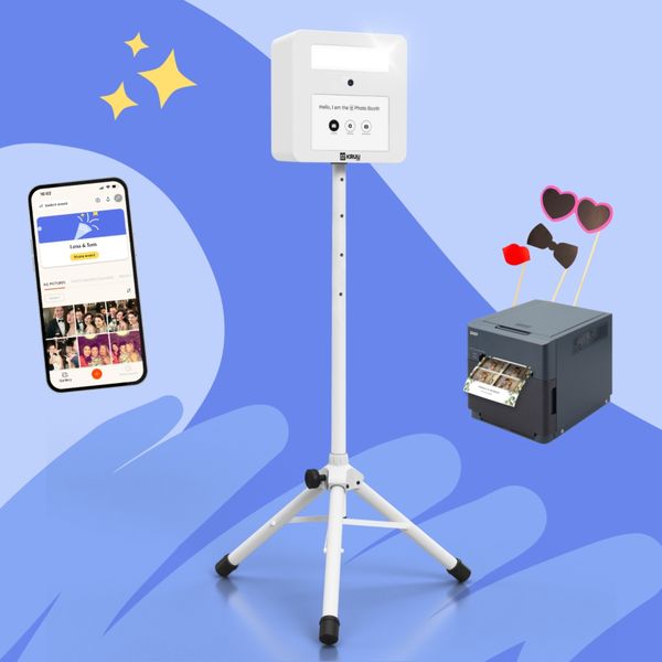 KRUU Photo Booth kit featuring a white photo booth on a stand, a highspeed printer with props, and a mobile phone displaying the KRUU App, set against a blue background.
