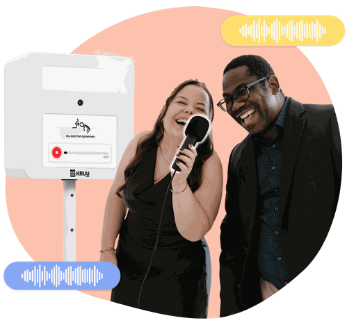 Two happy people holding a microphone in front of a KRUU photo booth, using the audio feature.