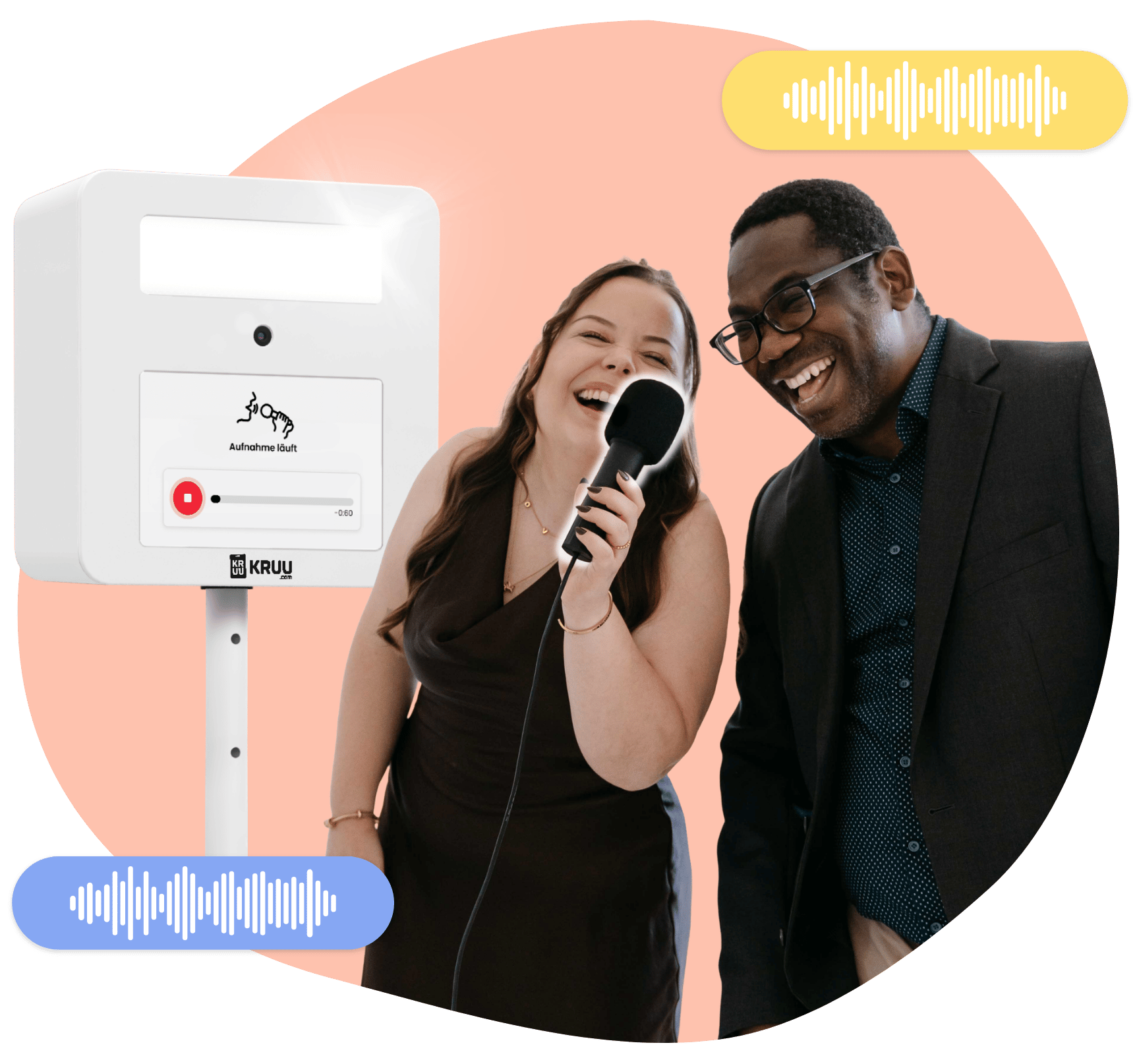Two happy people holding a microphone in front of a KRUU photo booth, using the audio feature.