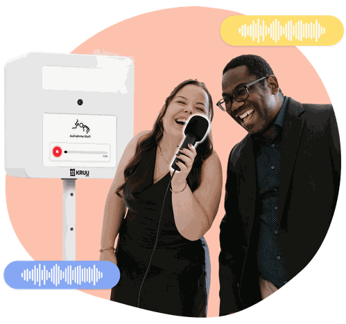 Two happy people holding a microphone in front of a KRUU photo booth, using the audio feature.