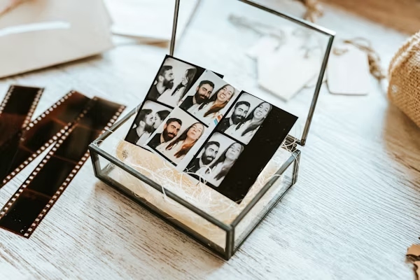 Wedding keepsake idea: Glass memory box filled with photo booth strips. Rustic storage for instant party prints.