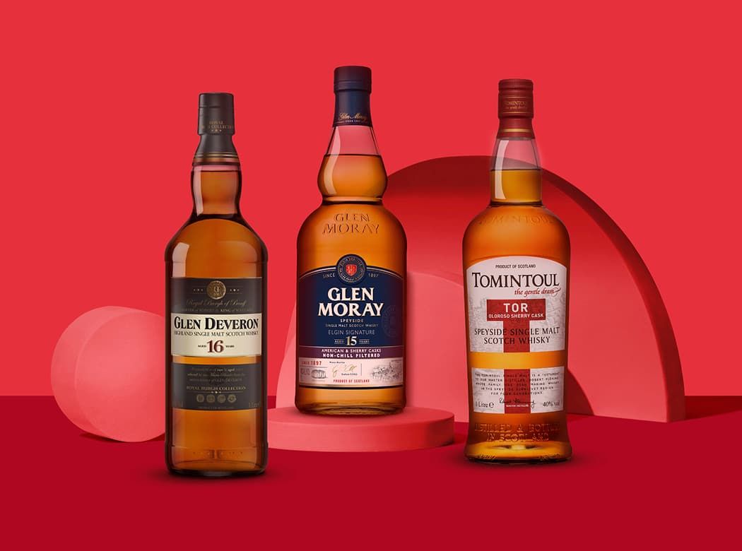 Three bottles of whisky—Glen Deveron 16, Glen Moray 15, and Tomintoul Speyside—on a red backdrop with geometric shapes.