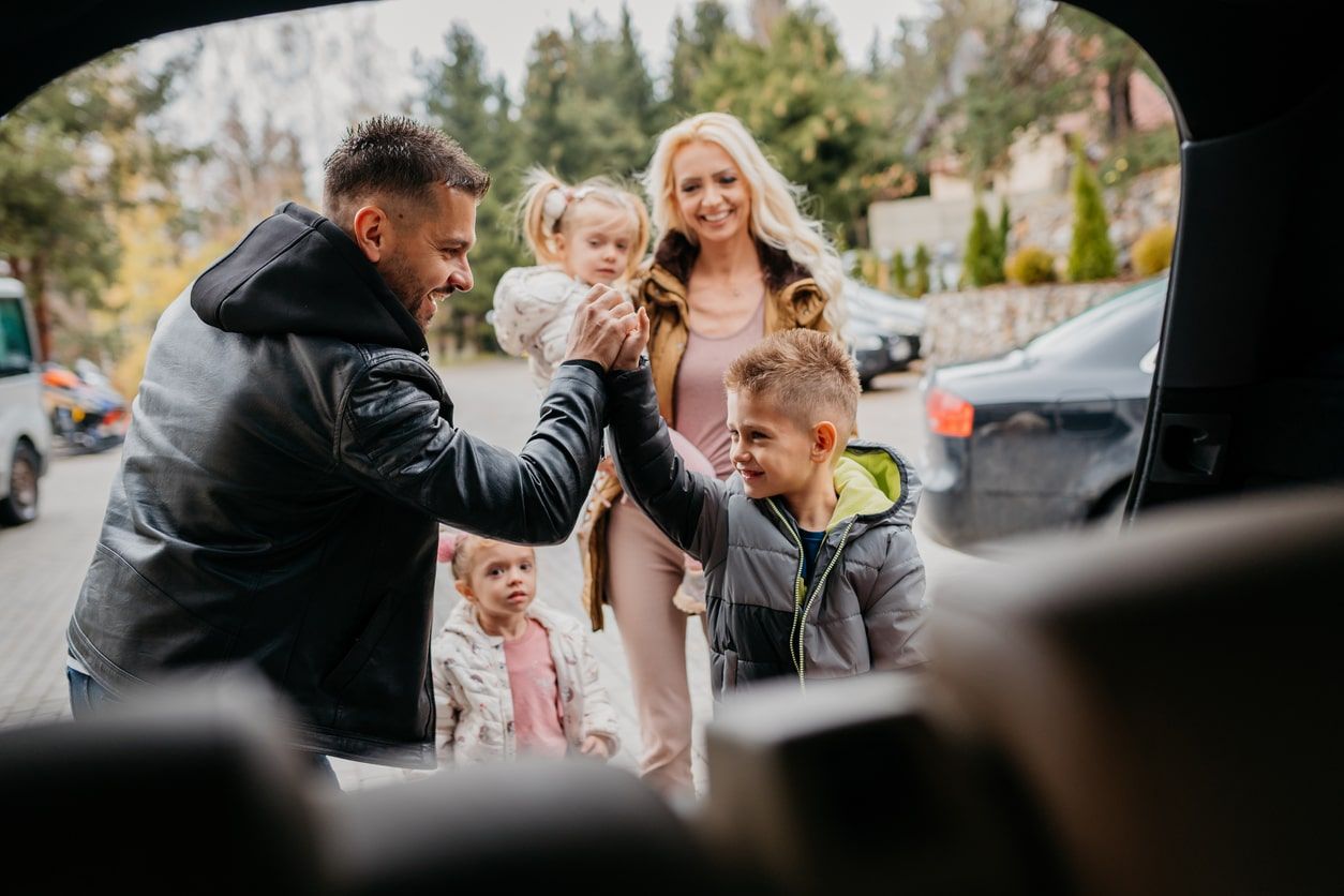 Image of mum and dad with 3 little children, dad and son are celebrating with a high five