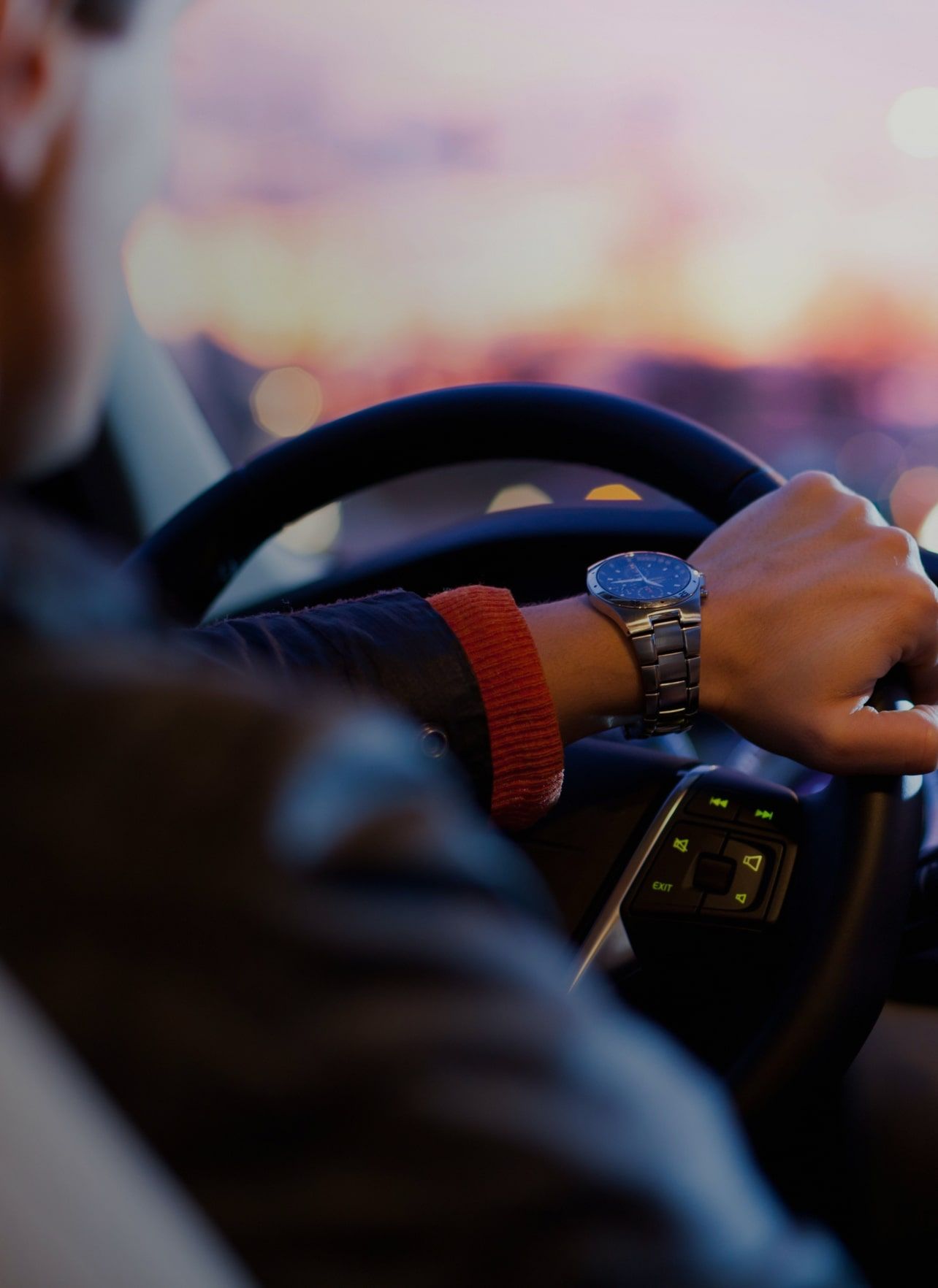 Image of man driving car with watch on wrist