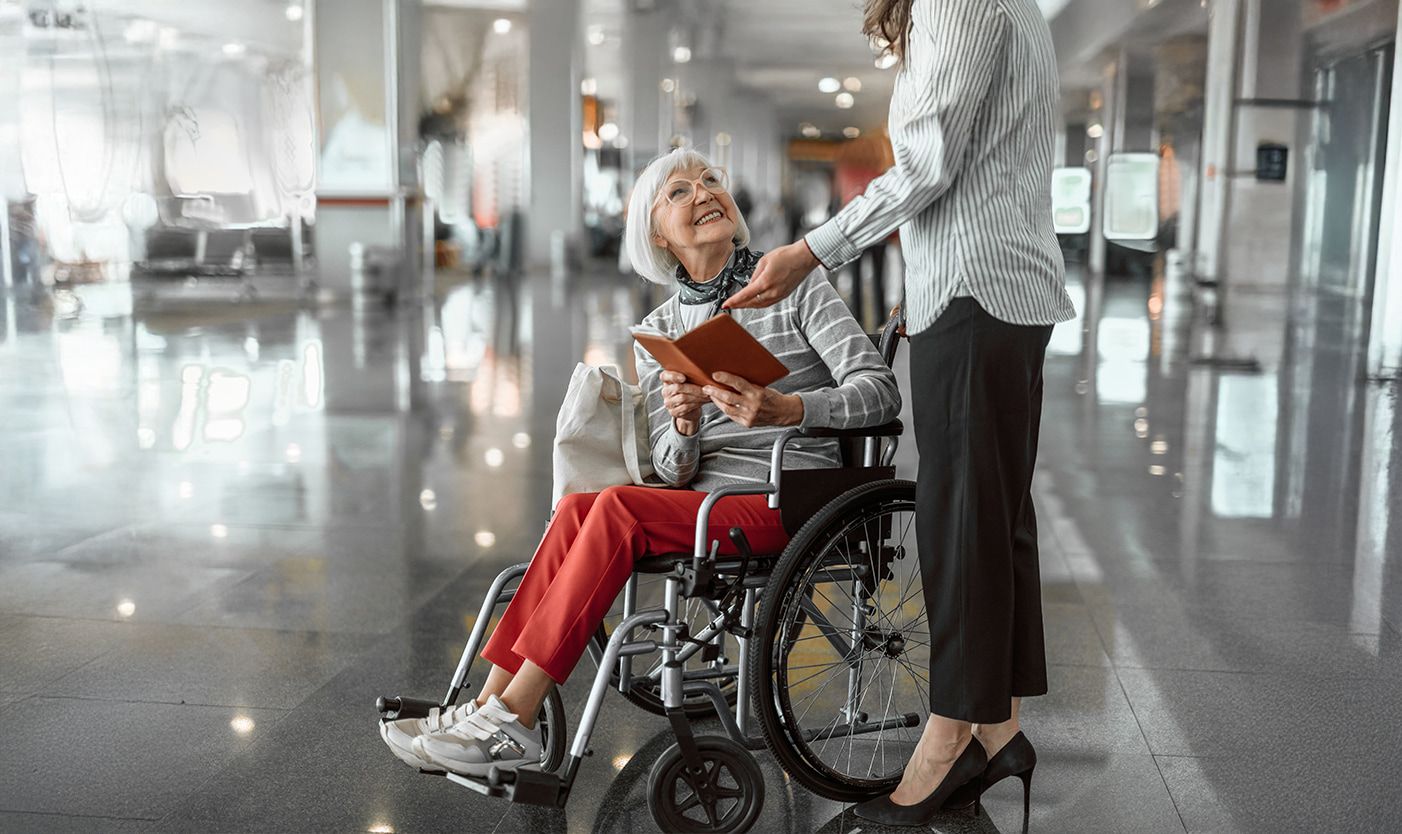 Woman in wheelchair smiling and looking up at woman