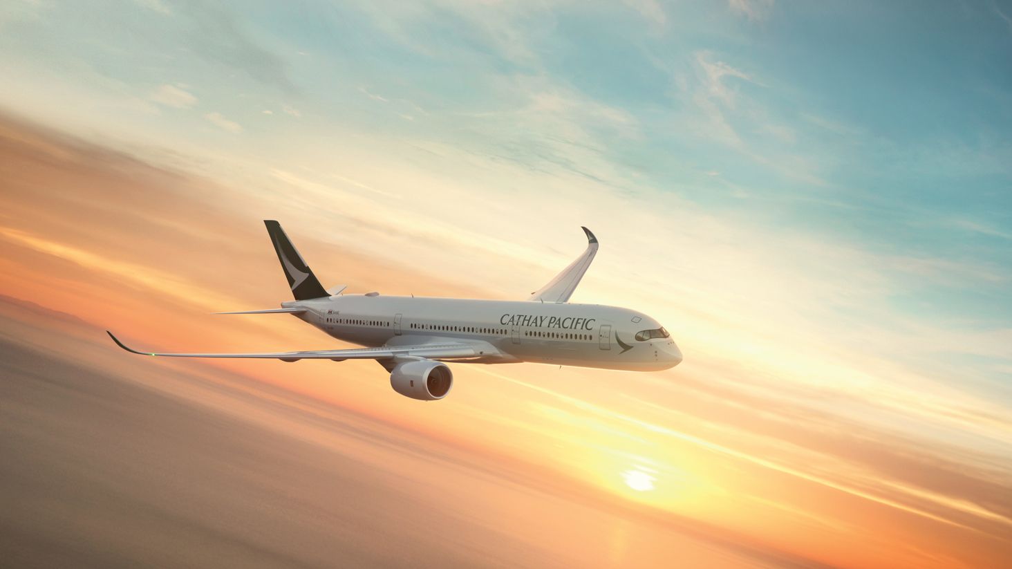 Airplane in Cathay Pacific livery soars through a colourful sunset sky, with white clouds and a gentle sunlight glow.