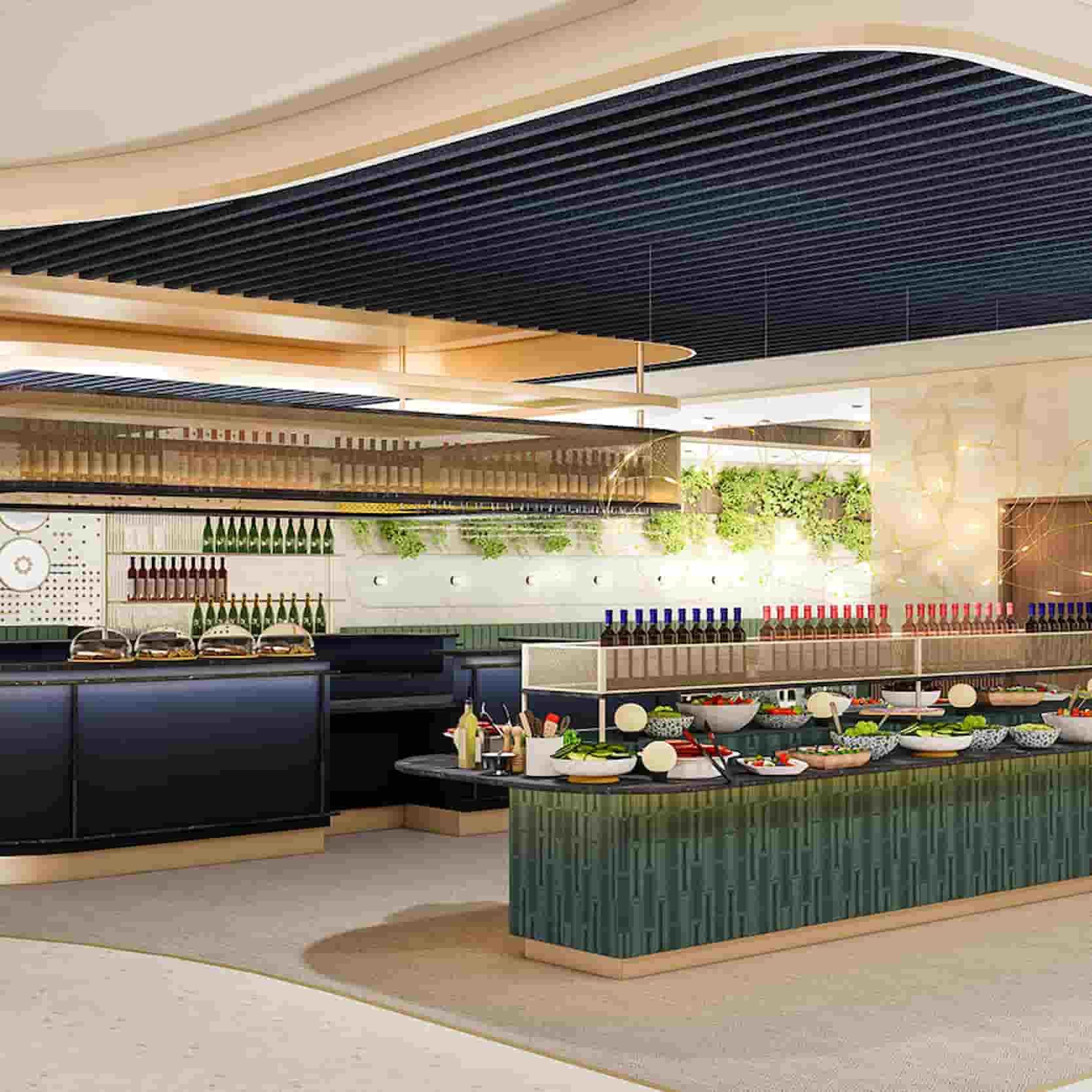 Modern buffet with assorted salads and dishes on a green-tiled counter, arranged under a stylish ceiling with wine bottles in the background.
