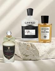 Three elegant perfume bottles displayed on a textured stone surface under soft lighting, showcasing luxury fragrances.