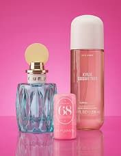 Three cosmetic bottles on a pink background: a blue perfume bottle, a small pink tube, and a tall pink lotion bottle.