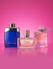 Three perfume bottles are displayed on a pink background. The bottles vary in shape and color: blue, pink, and clear with pink liquid.