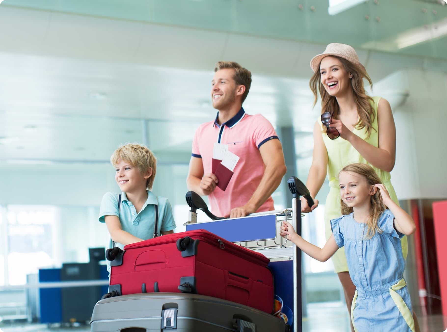 Happy family pushing luggage trolley