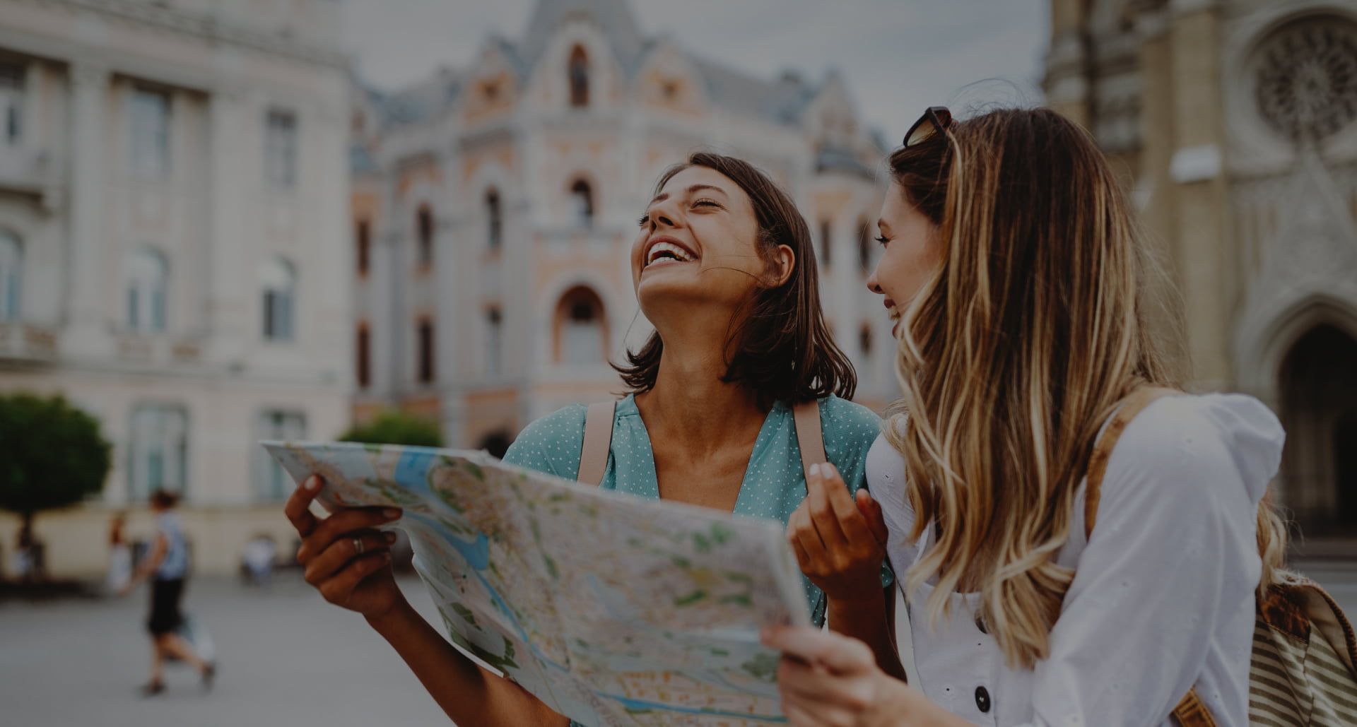 Two women looking at map laughing