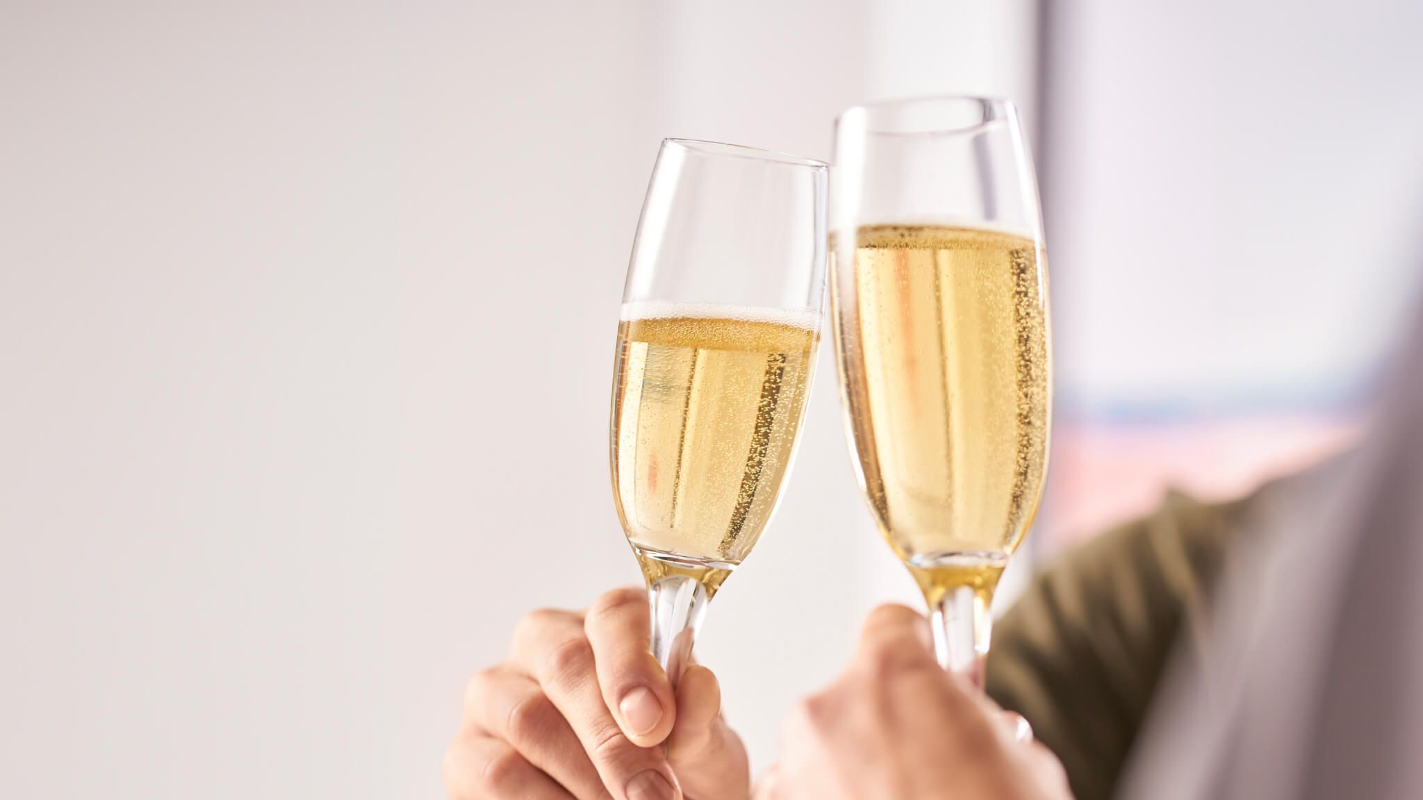 two people clinking glasses of sparkling wine