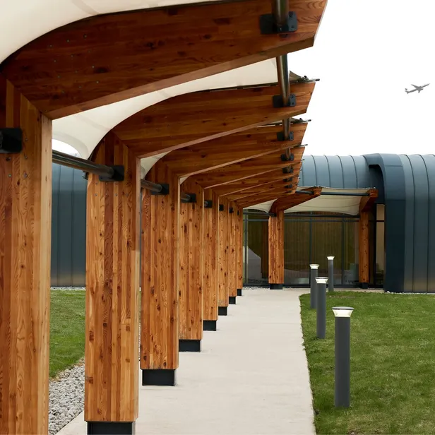 Image of the aether exterior, showing a covered walkway with bright, natural wood, and cloth coverings