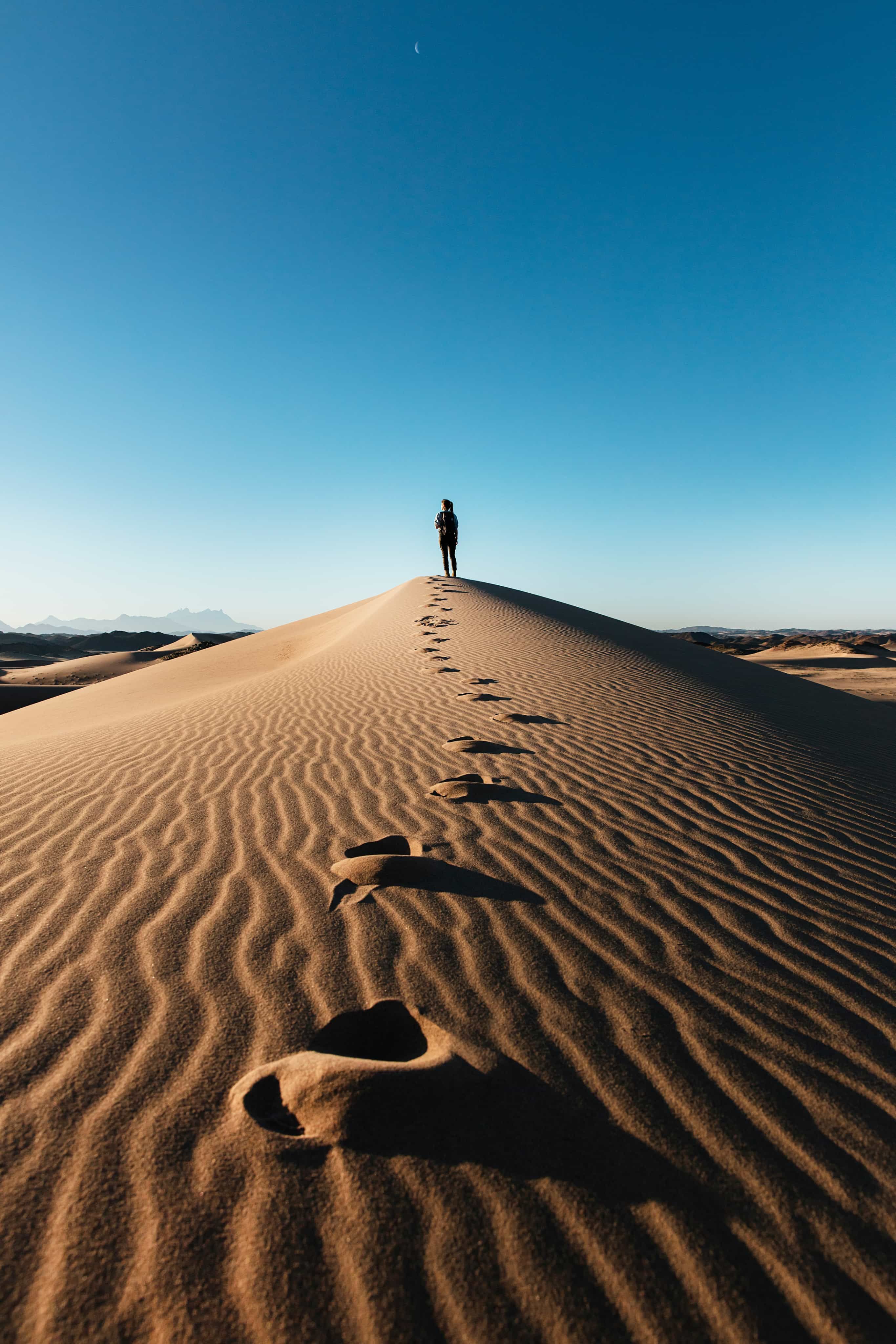 Woman standing at top of sand hill