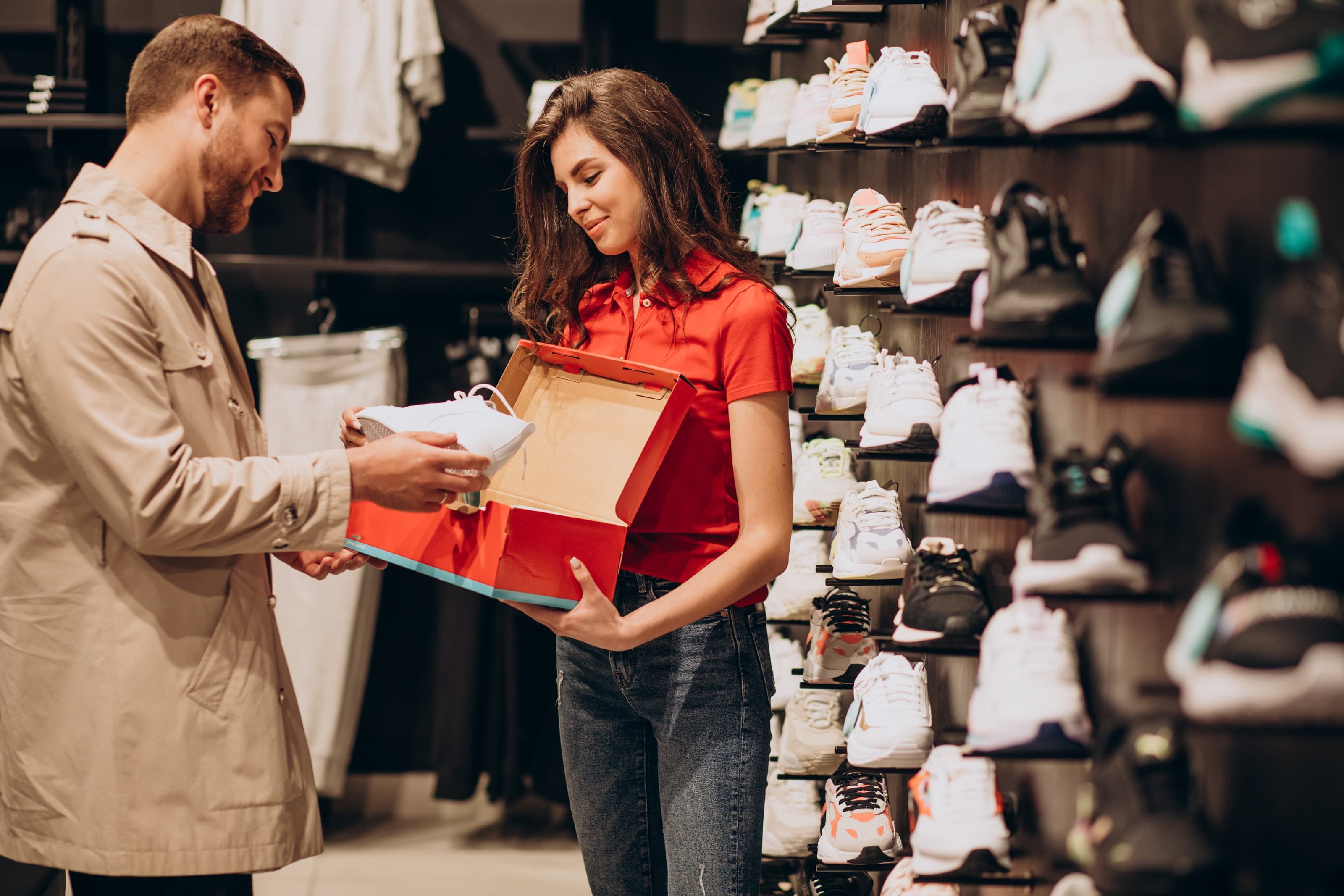 Shop staff member showing shoe in box to customer