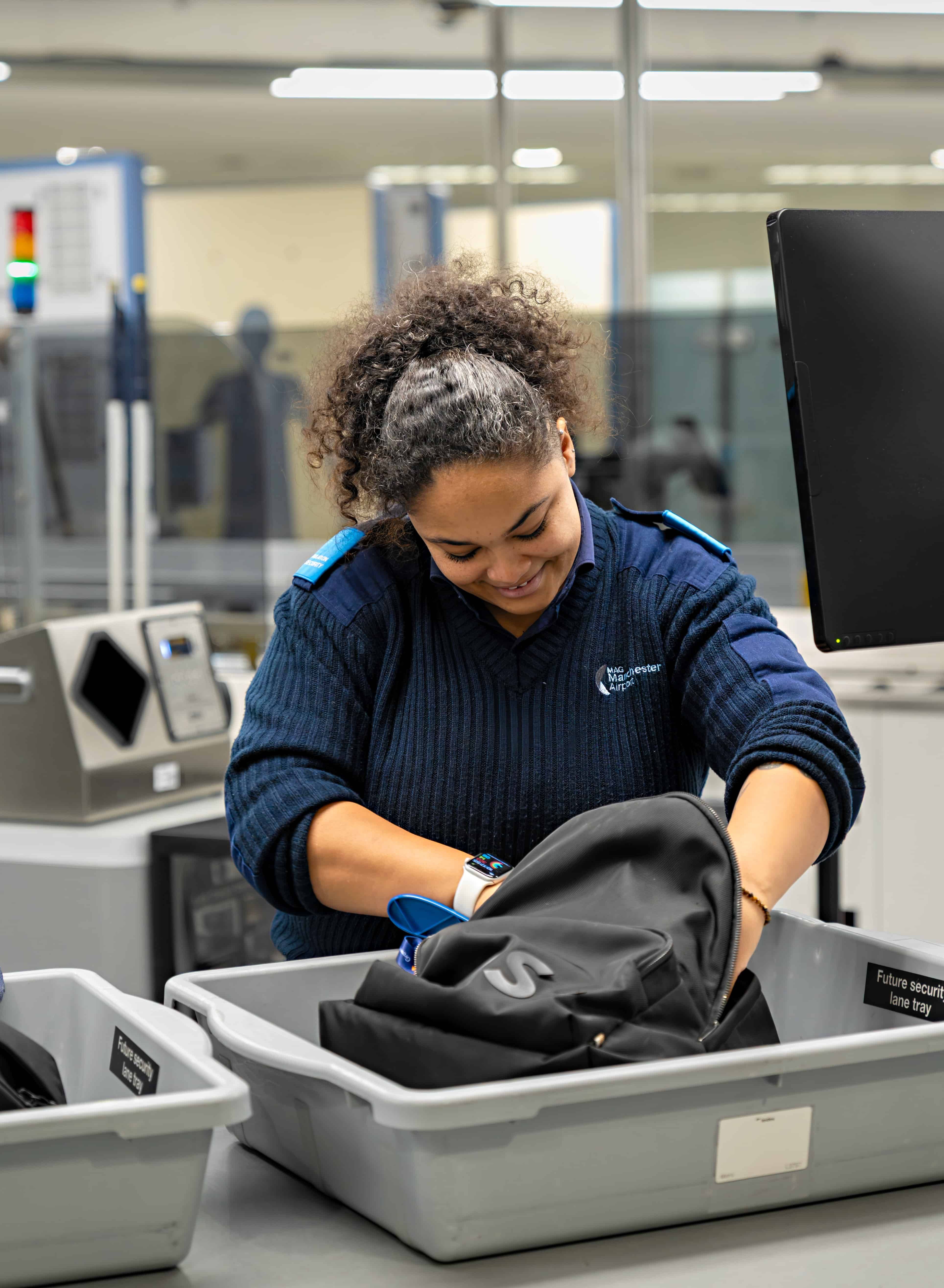 Woman checking bag in Security lane