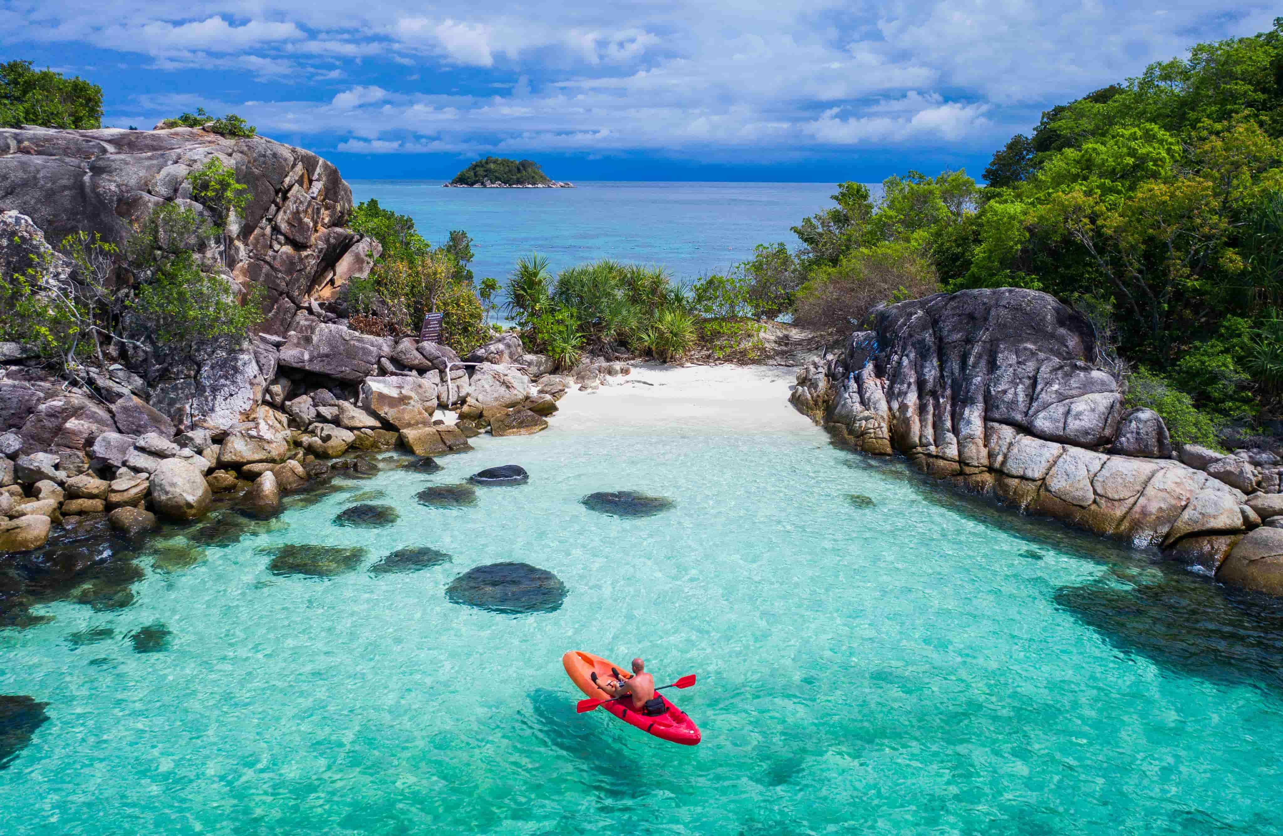 Man kayaking in blue cove