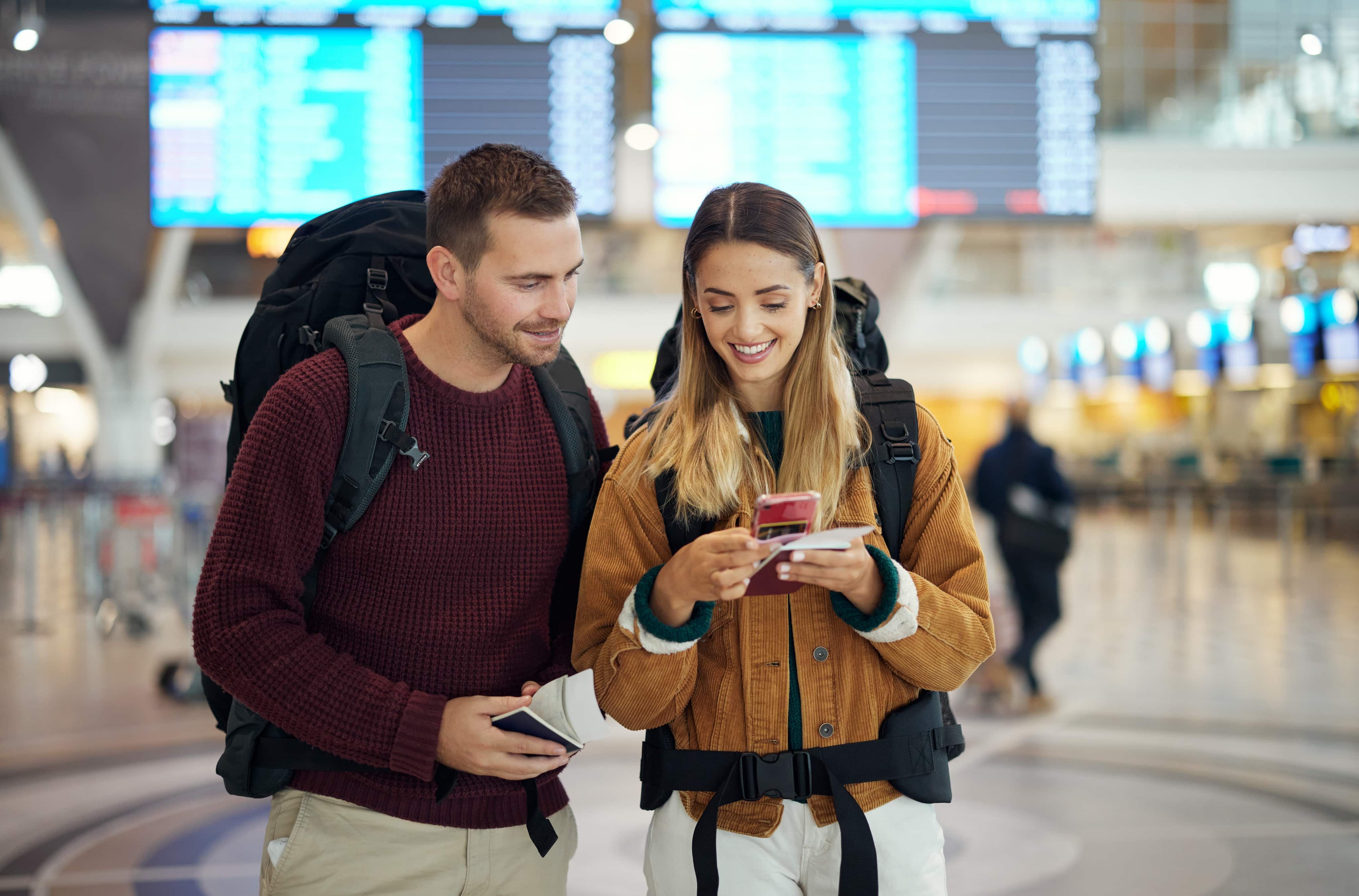 Man and woman travelling looking at phone