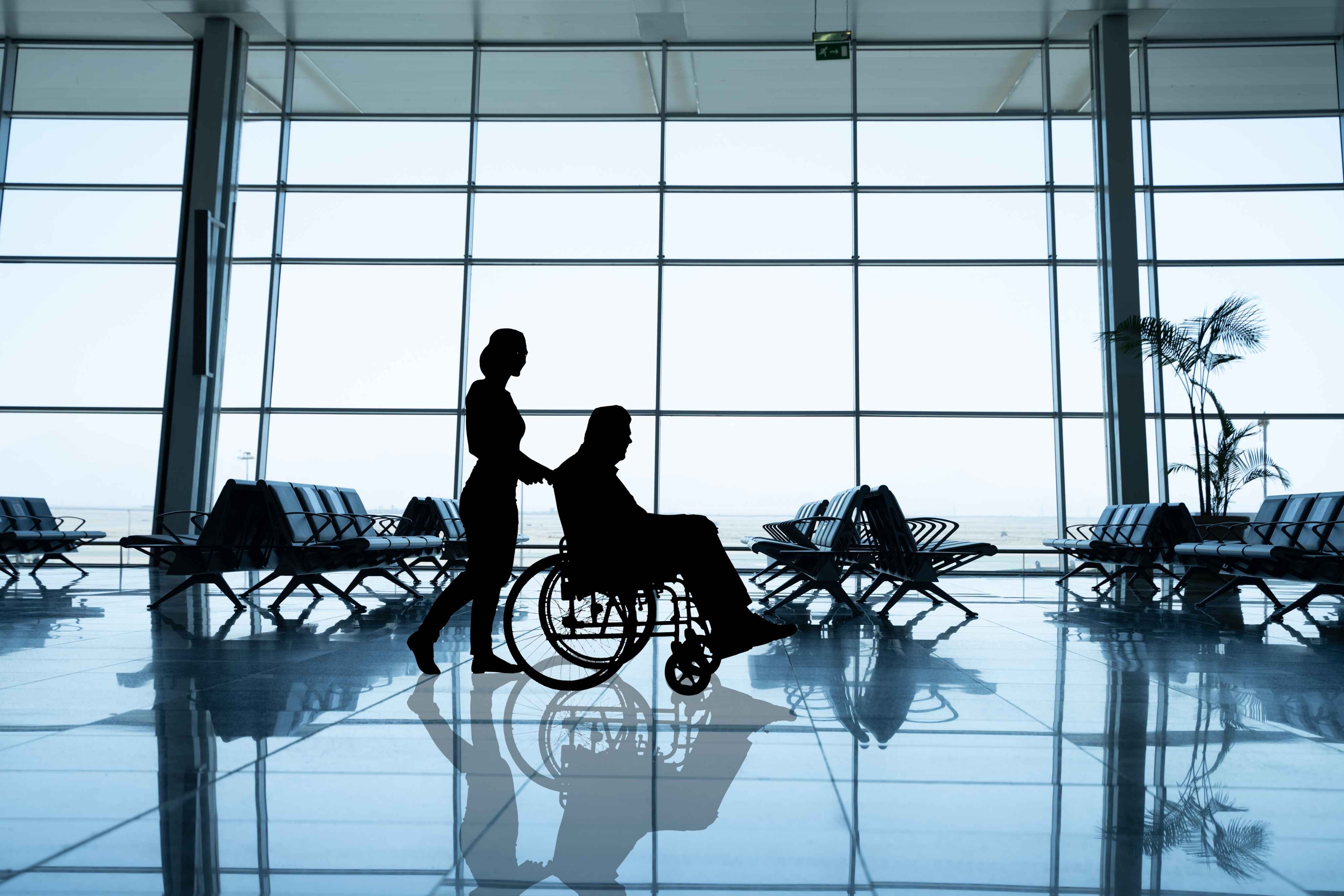person being pushed through airiport in wheelchair
